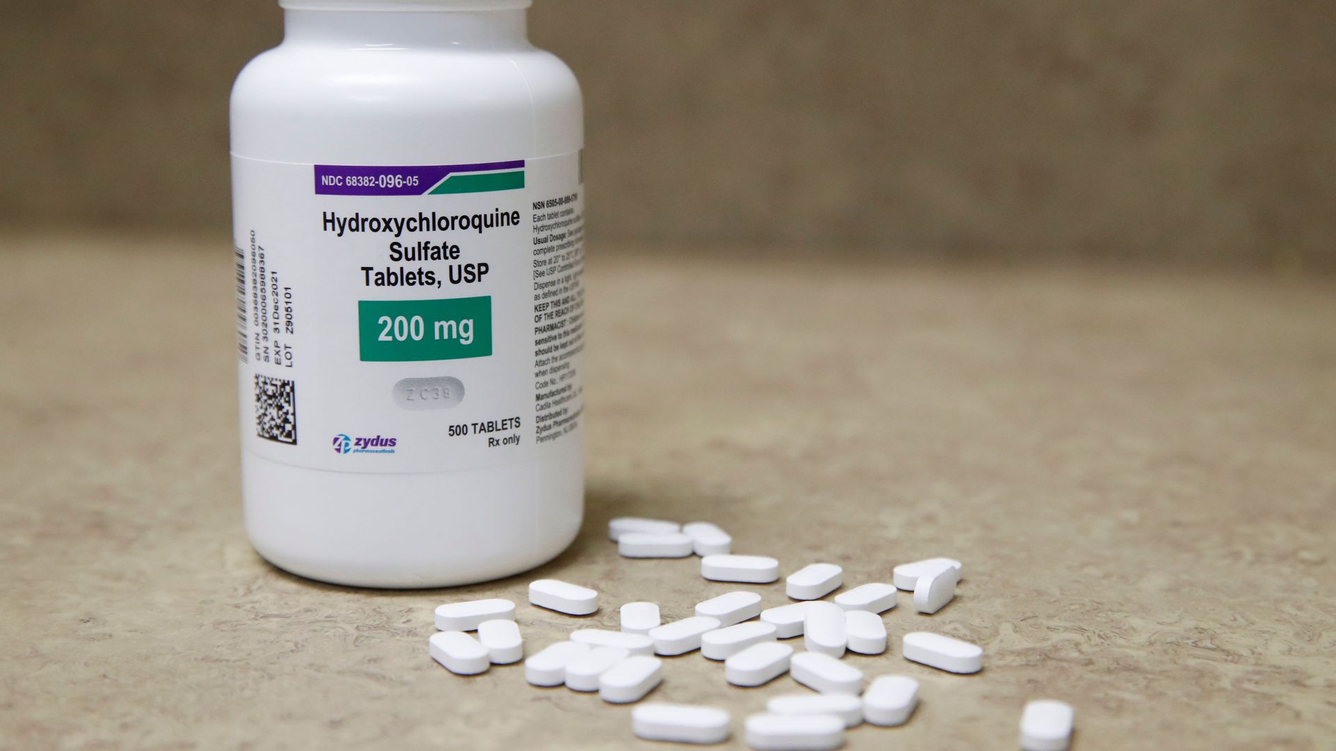 Photo of a bottle of hydroxychloroquine with pills on the sidd
