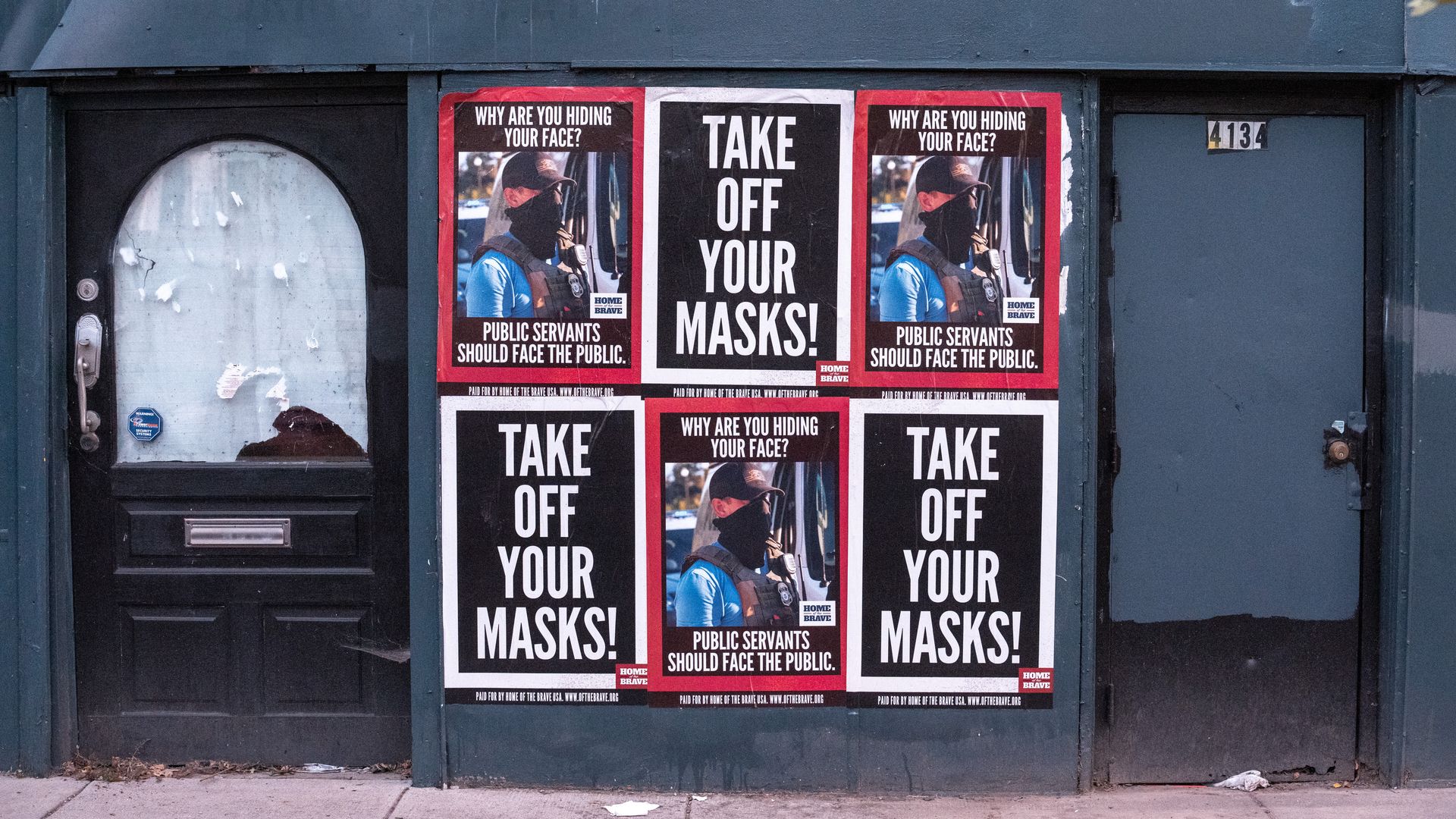 The side of a building in Washington, D.C., with signs read "Take off your masks!"