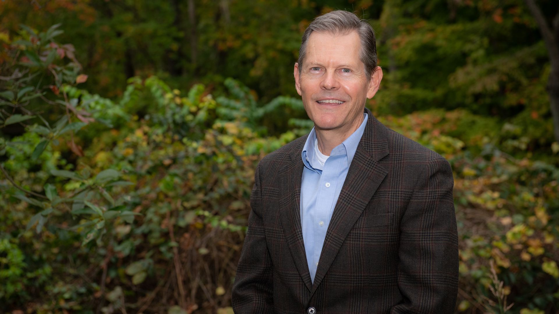 New Columbus Zoo and Aquarium president and CEO Tom Schmid poses for a professional headshot in front of trees