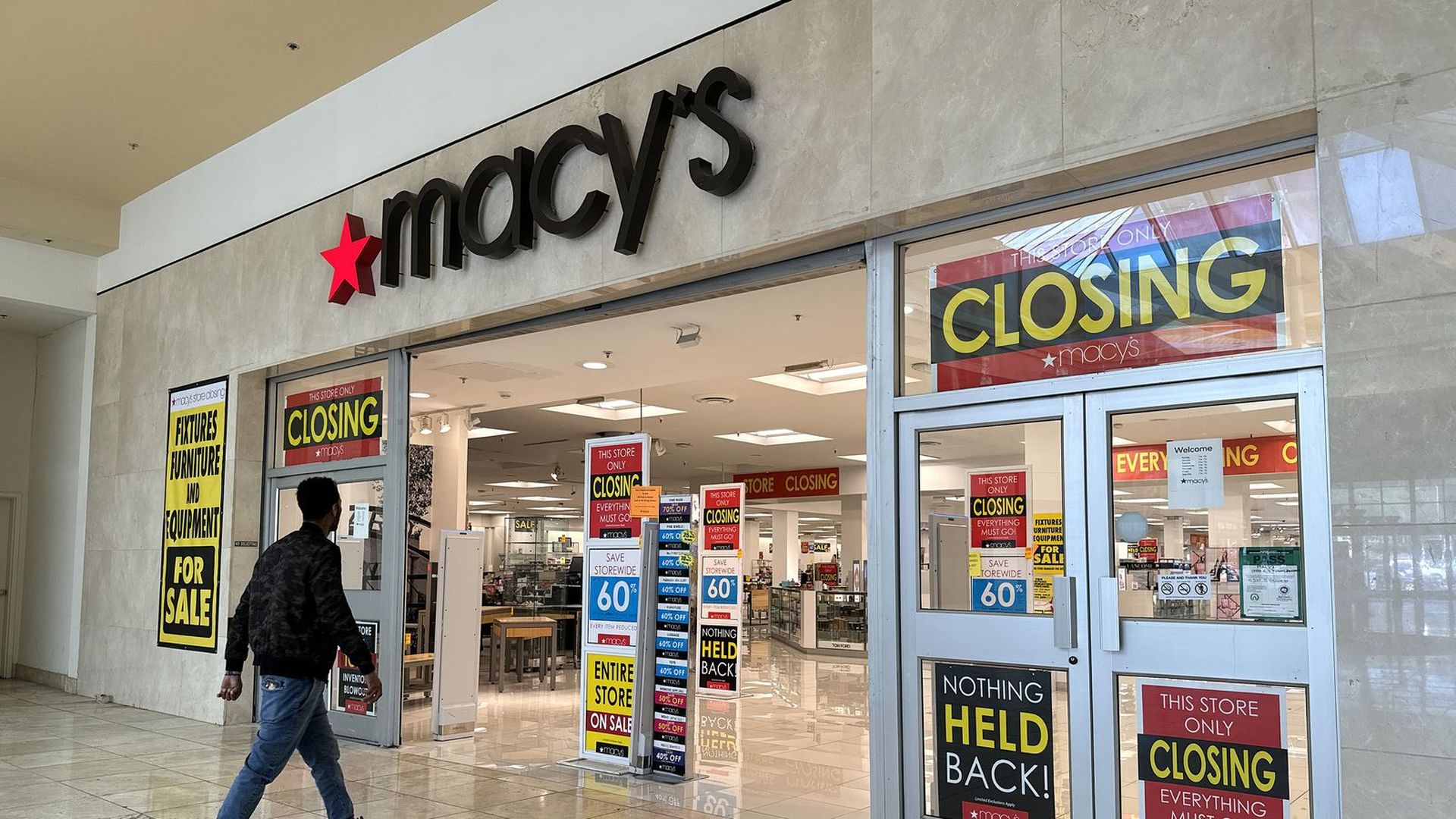 A customer enters a closing Macy's store
