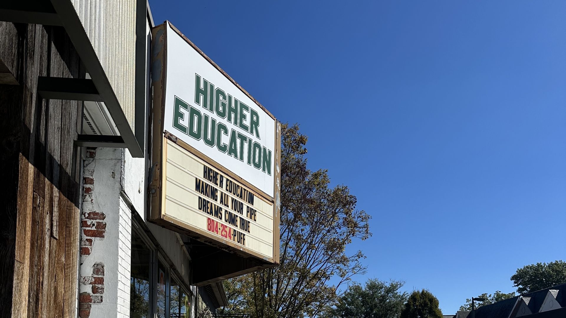 A sign on a Carytown store that says Higher Education 