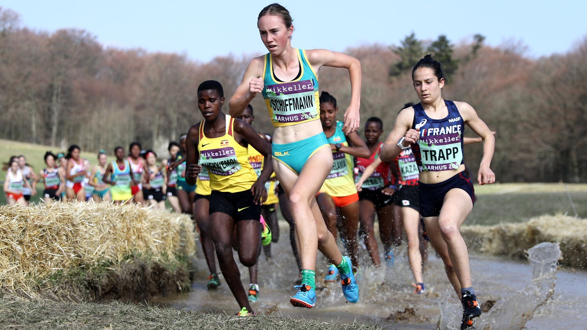 Women running through muddy terrain