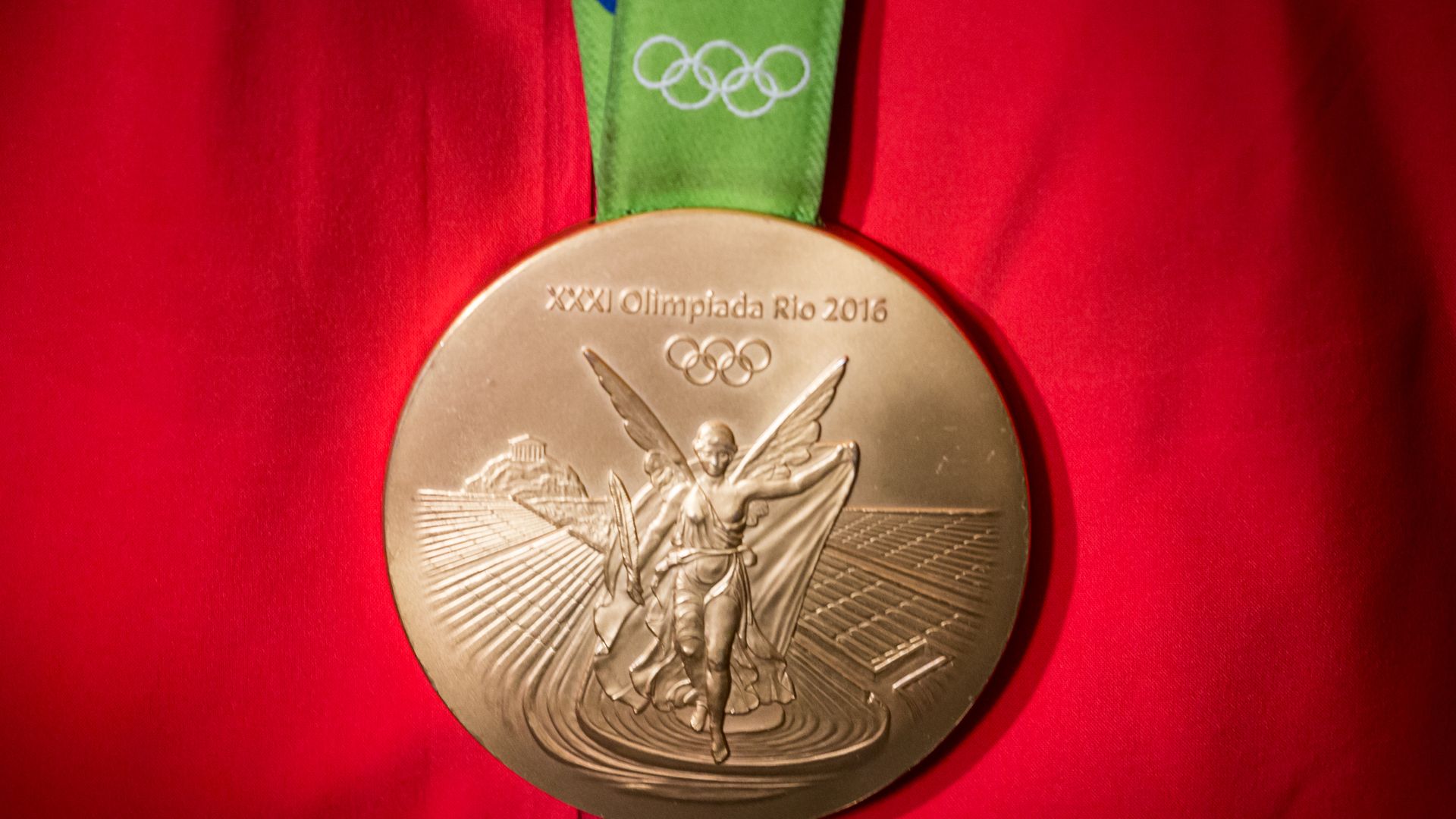 Photo of a bronze Olympic medal against a red jacket