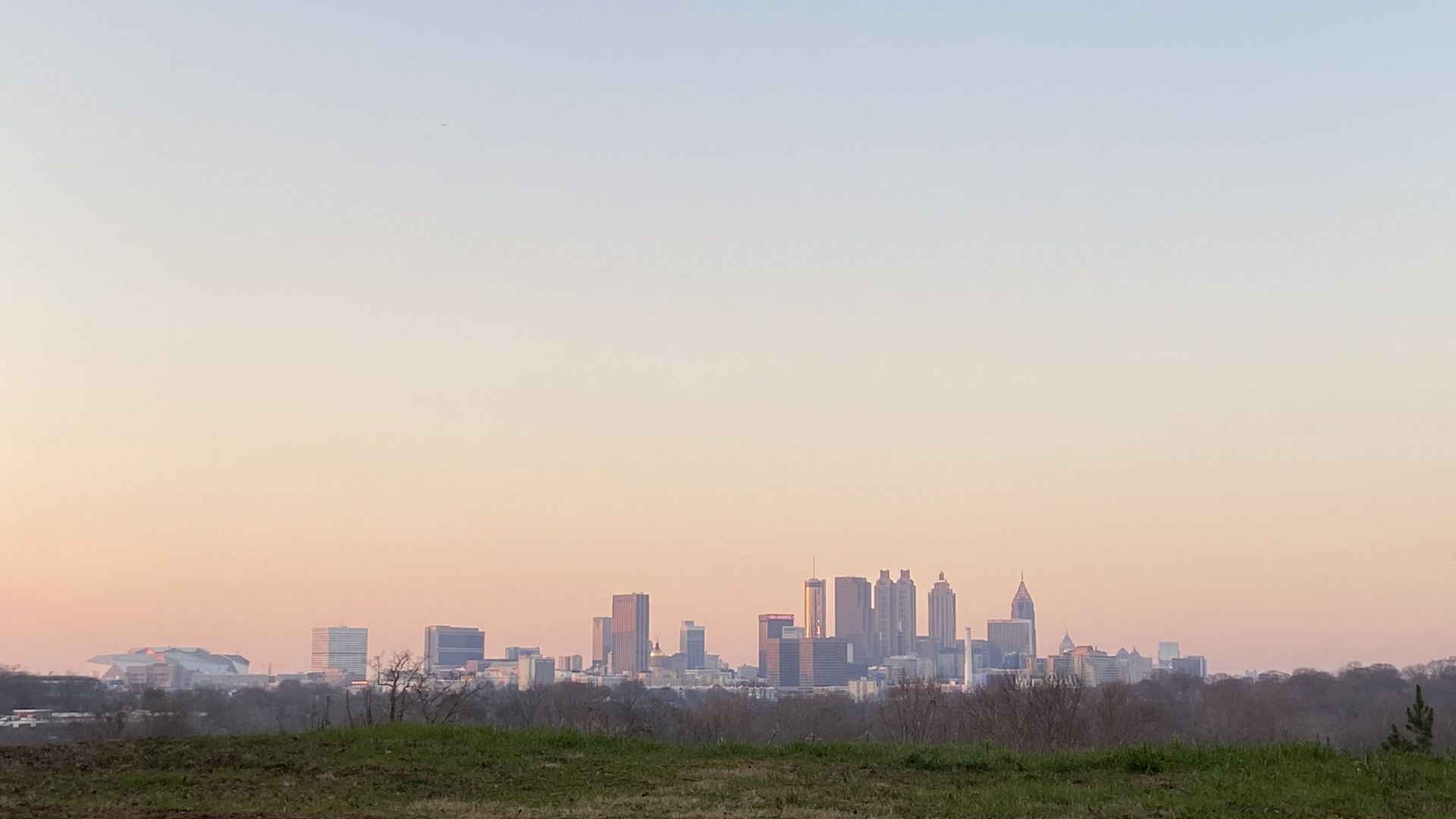 A photo of the Atlanta skyline from a hilltop at dusk