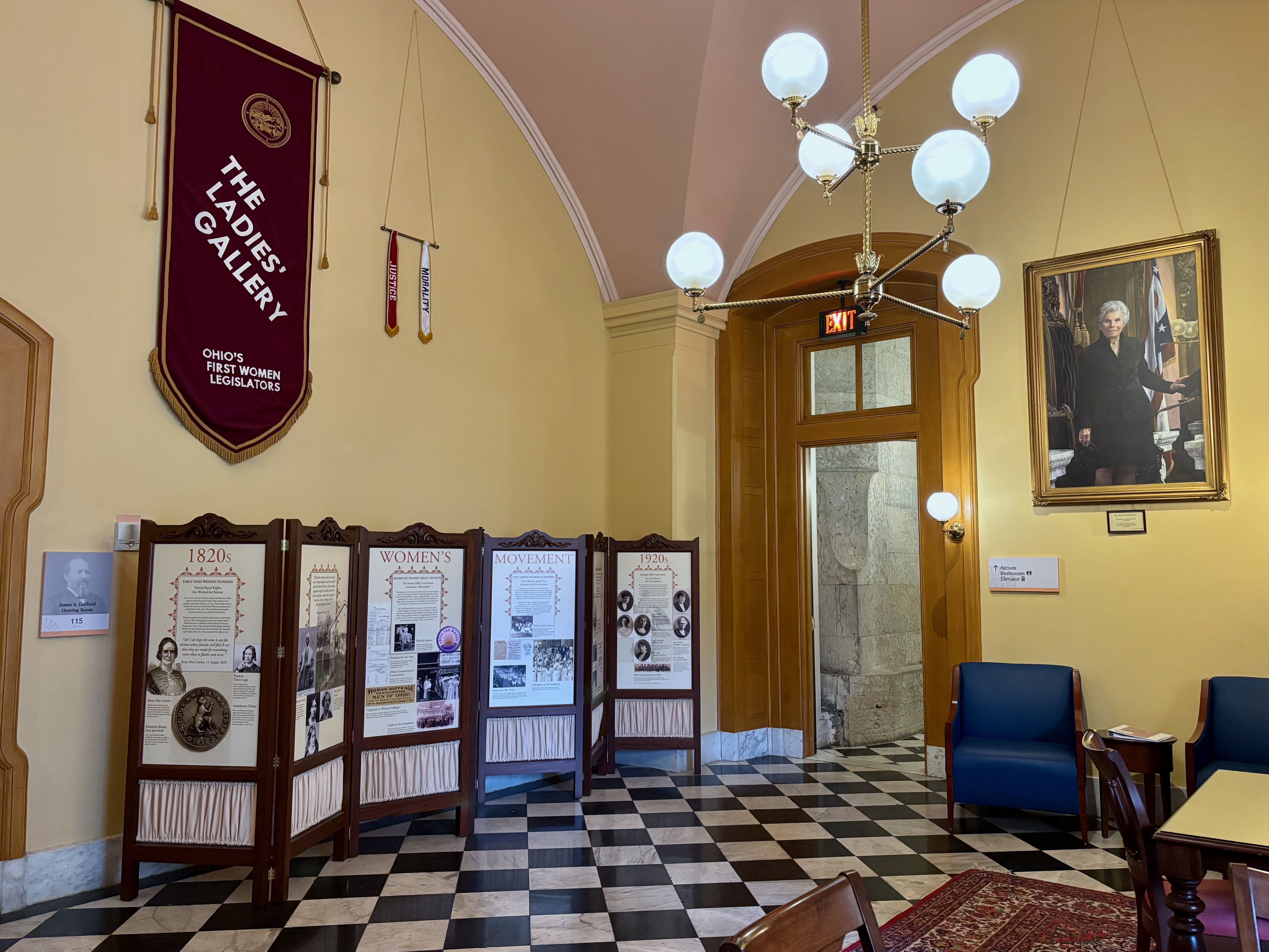 The other side of the Ladies' Gallery, featuring a banner and a historical display board regarding women's suffrage