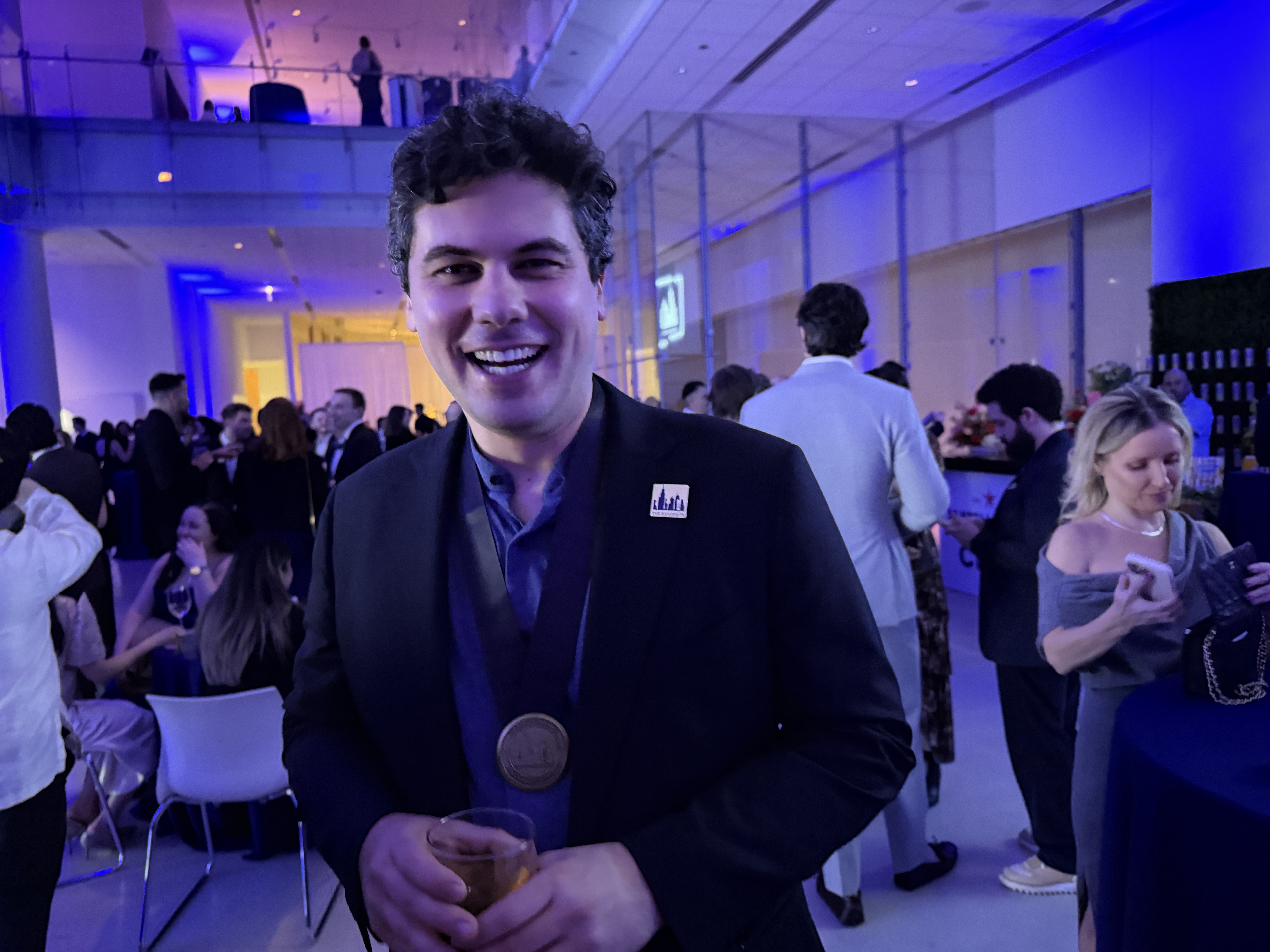 A guy in a suit with a medal around his neck. 