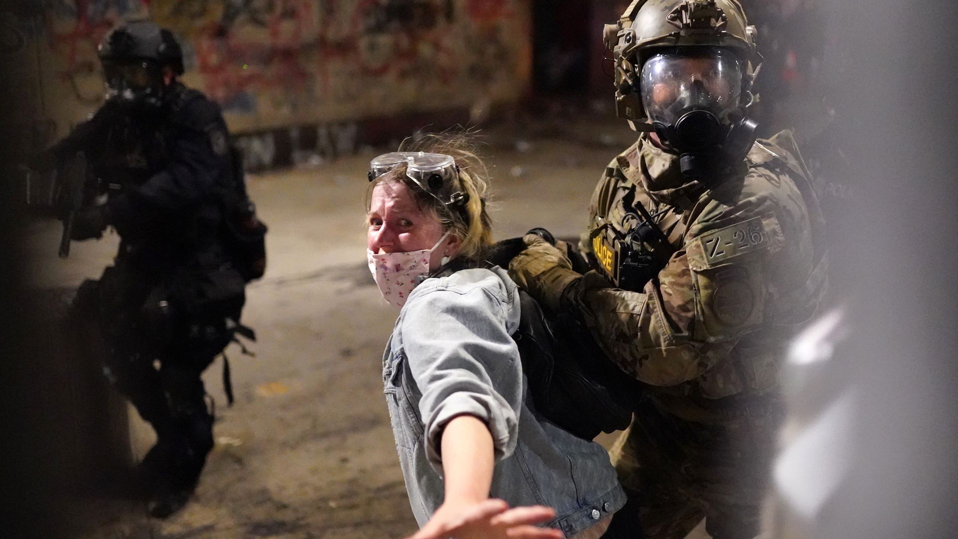 Federal officers arresting a protester for crossing a fence line around a federal courthouse.