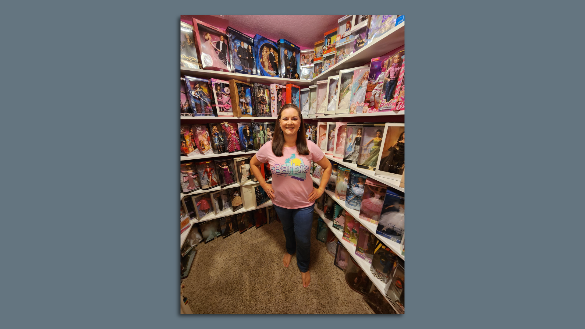A photo of a woman with a Barbie doll collection.