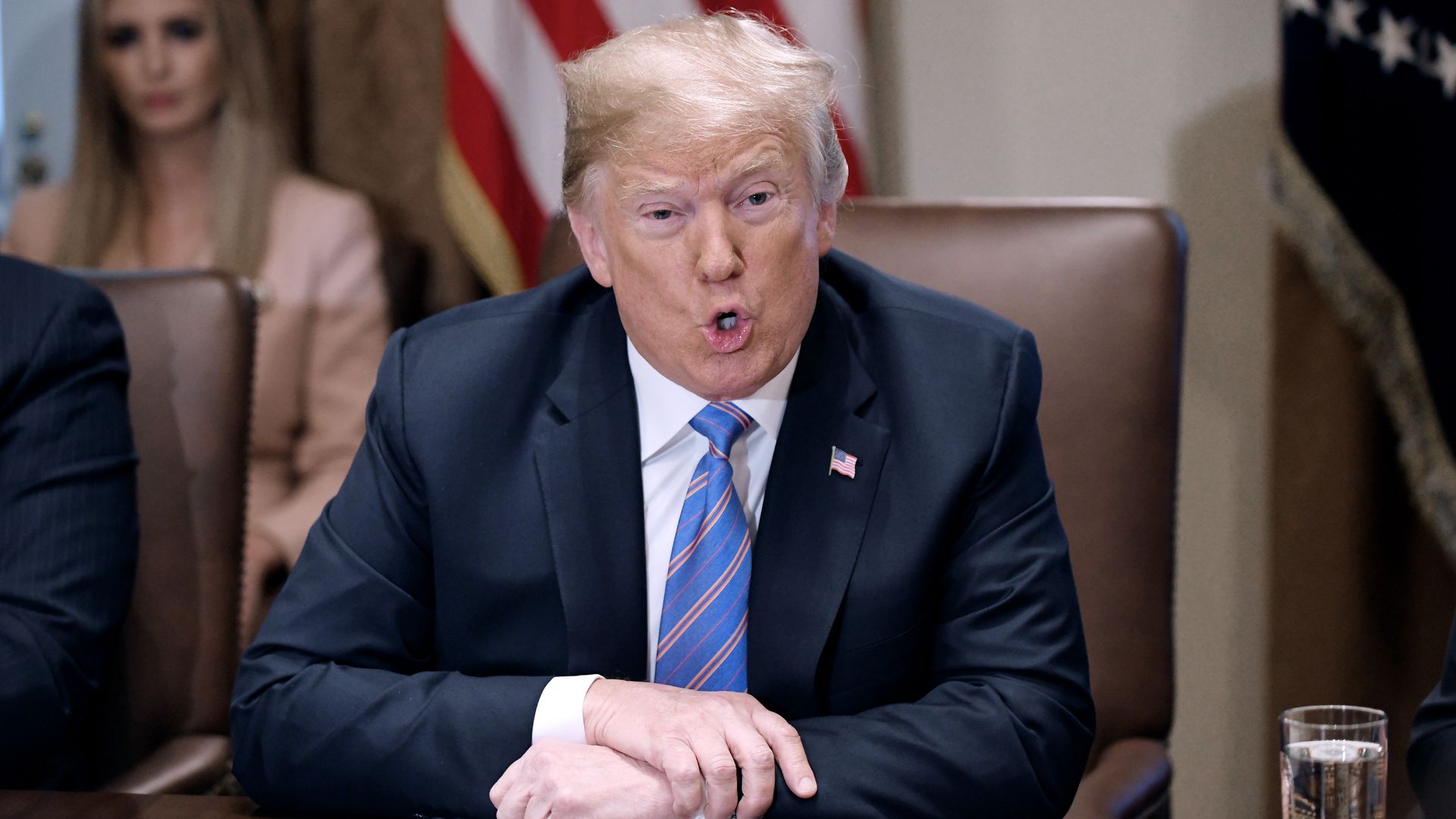 Donald Trump leans over his cabinet table while speaking energetically 