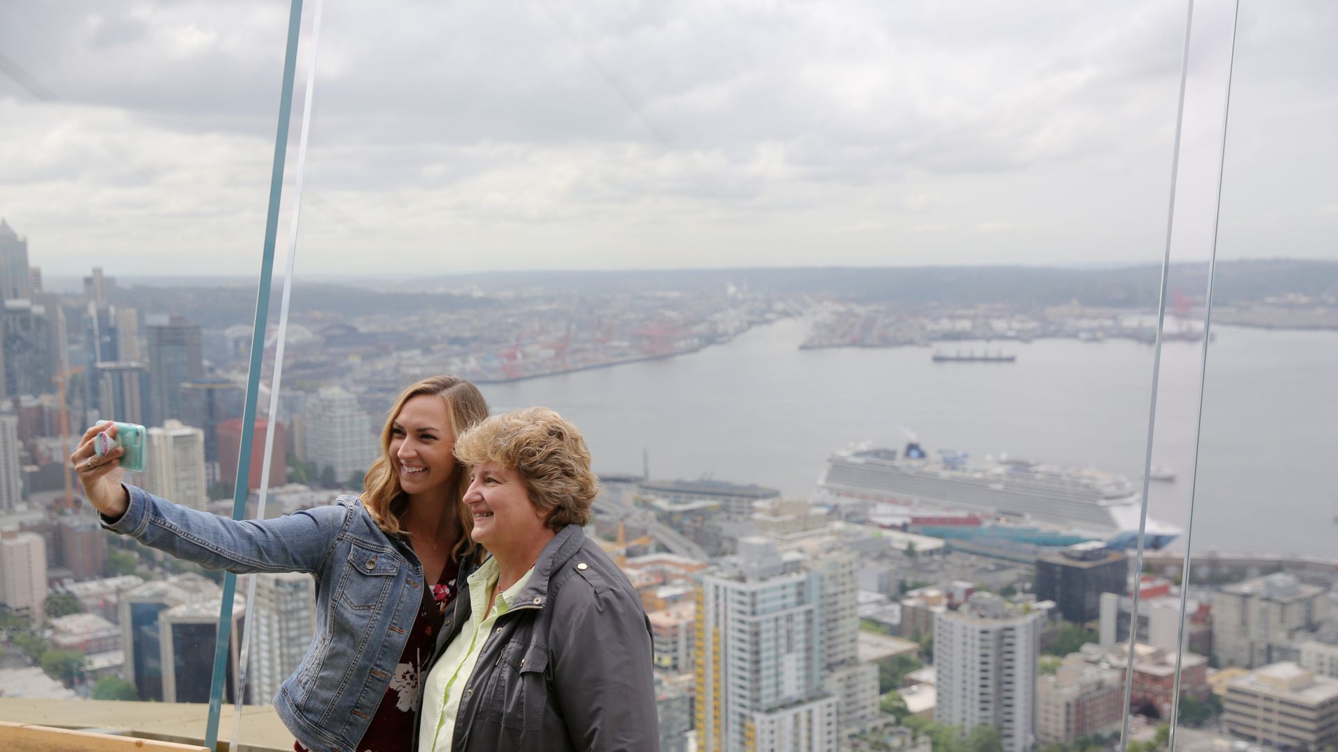 Two people taking a selfie from the observation deck on Seattle's Space Needle. 