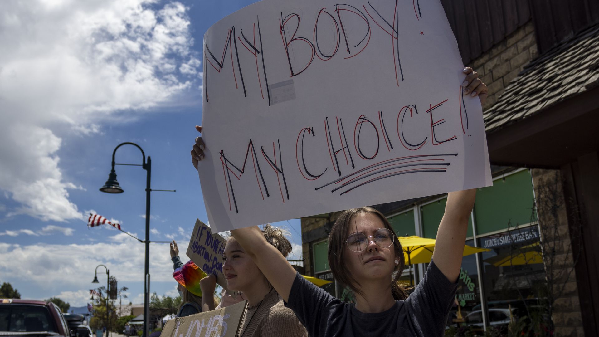 Photo of a group of teenagers holding up pro-abortion signs on a sidewalk