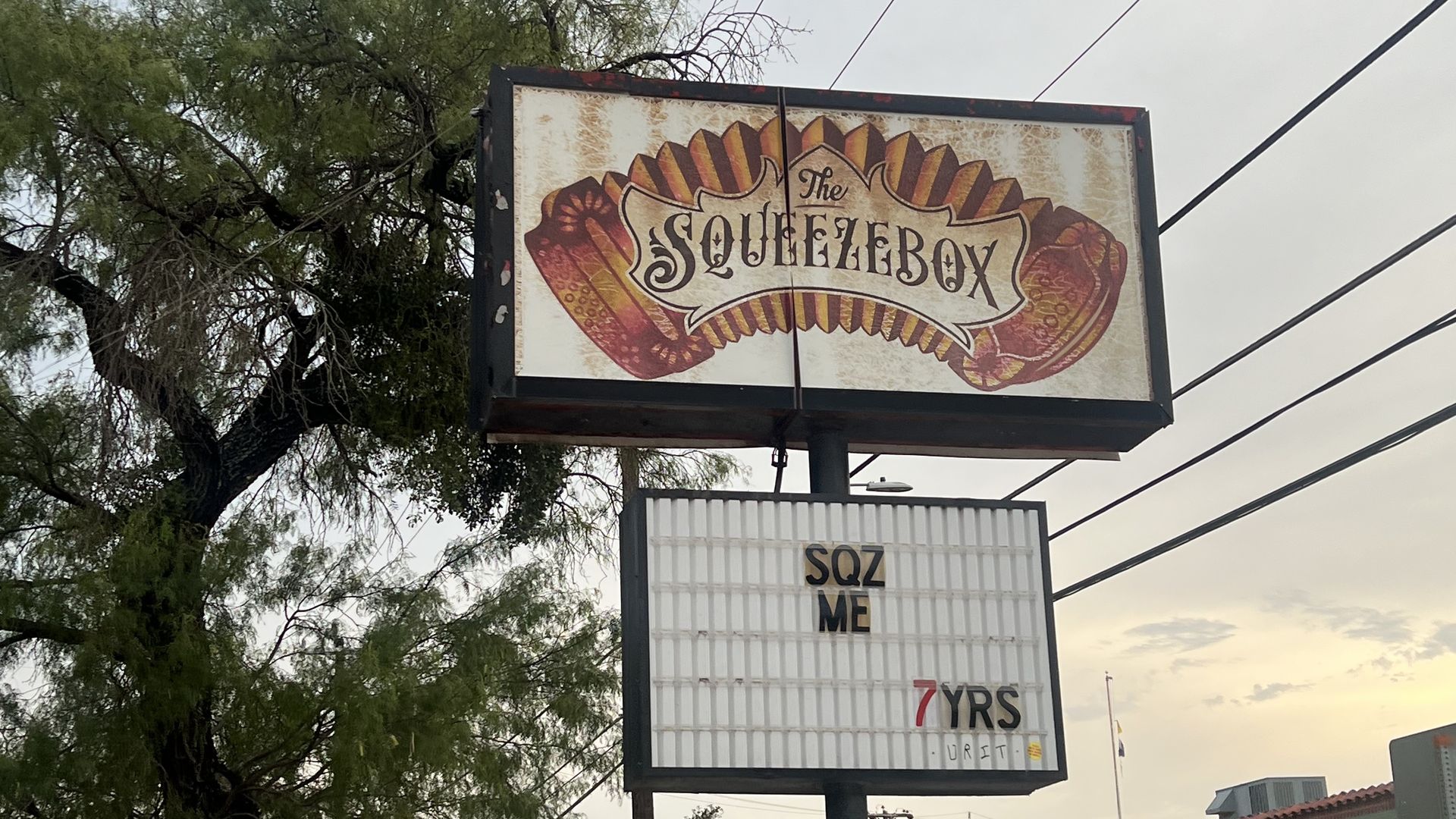 A marquee for the former Squeezebox reads "SQZ ME..7 YRS."