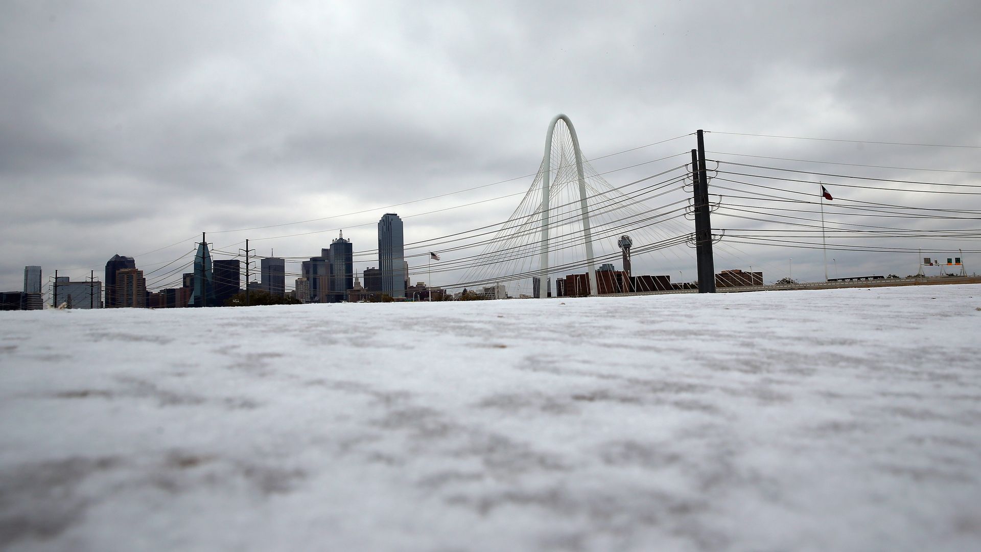 The Dallas skyline behind a field of icy grass.