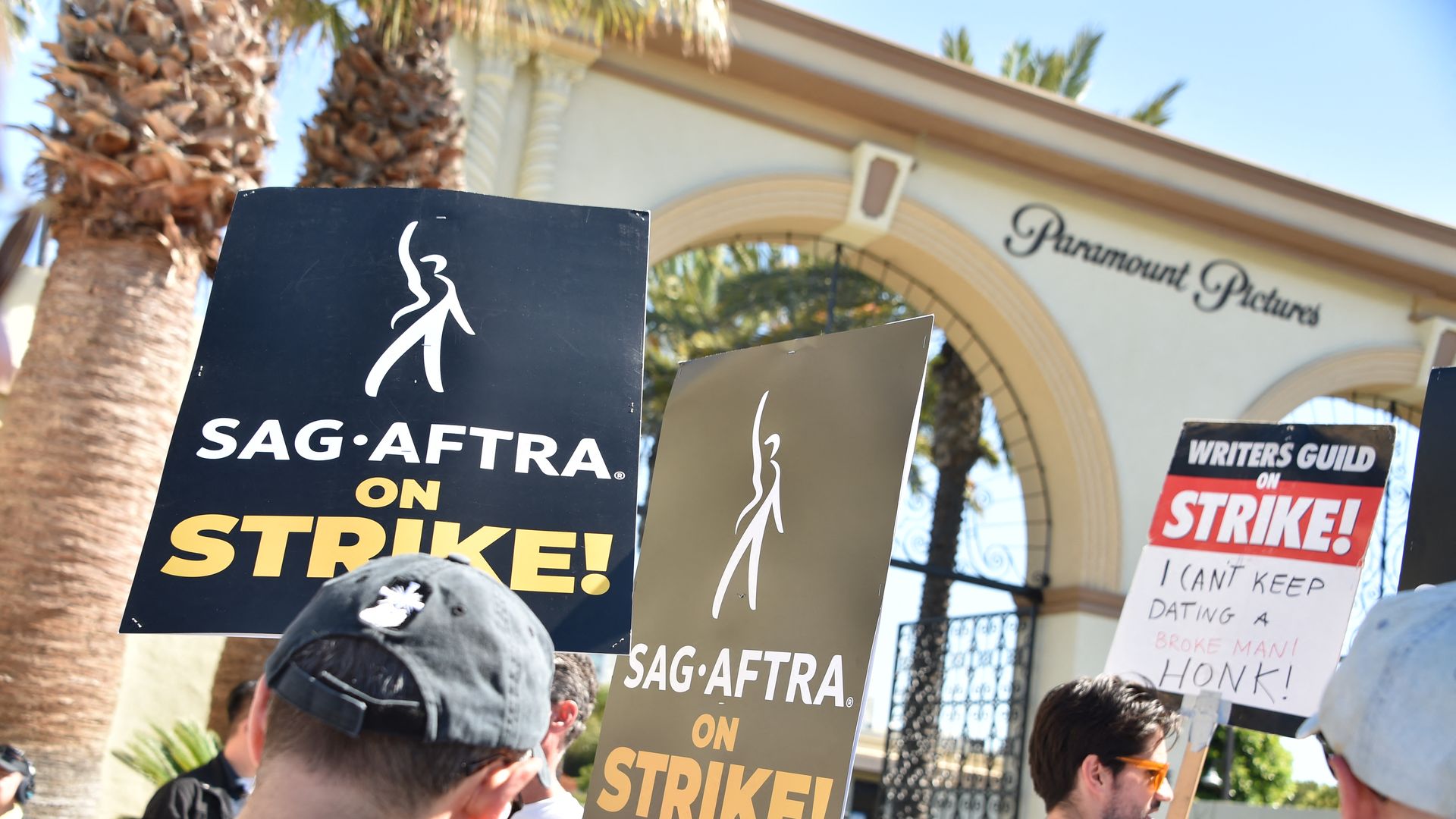 workers  hold up signs that say actors are on strike outside the paramount studios lot 