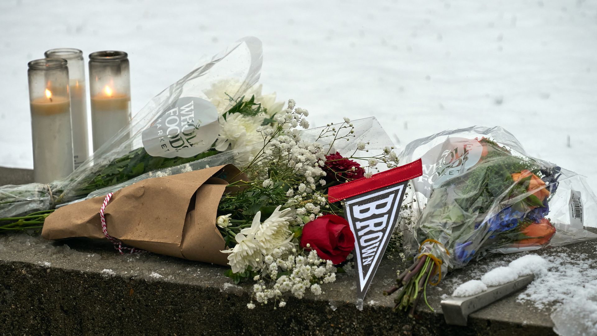 Flowers and candles are seen at a makeshift memorial outside the Barus & Holley engineering building on the campus of Brown University, in Providence, Rhode Island on December 14.
