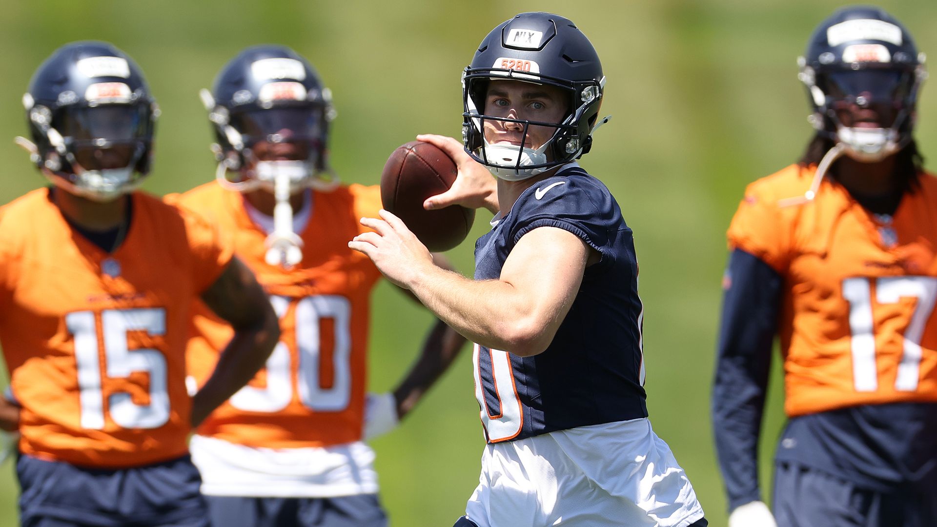A man in a helmet prepares to throw a pass.  
