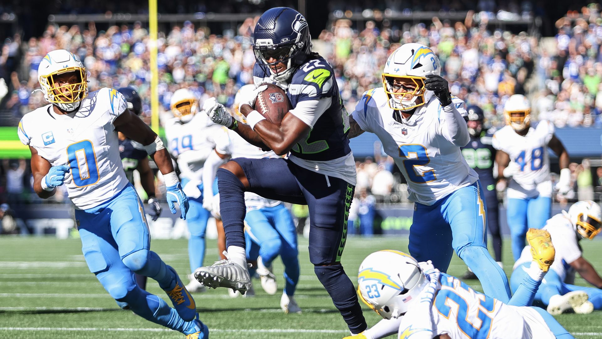 Seattle Seahawks receiver Rashid Shaheed carries the ball as he hurdles a Los Angeles Chargers defender at Lumen Field.