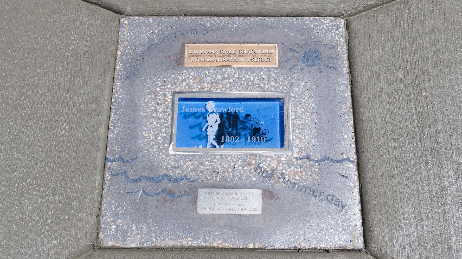 Sidewalk memorial with a bronze plaque reading "CHICAGO RACE RIOT of 1919 COMMEMORATION PROJECT" and a blue inset illustration of figures labeled 1882–1919.
