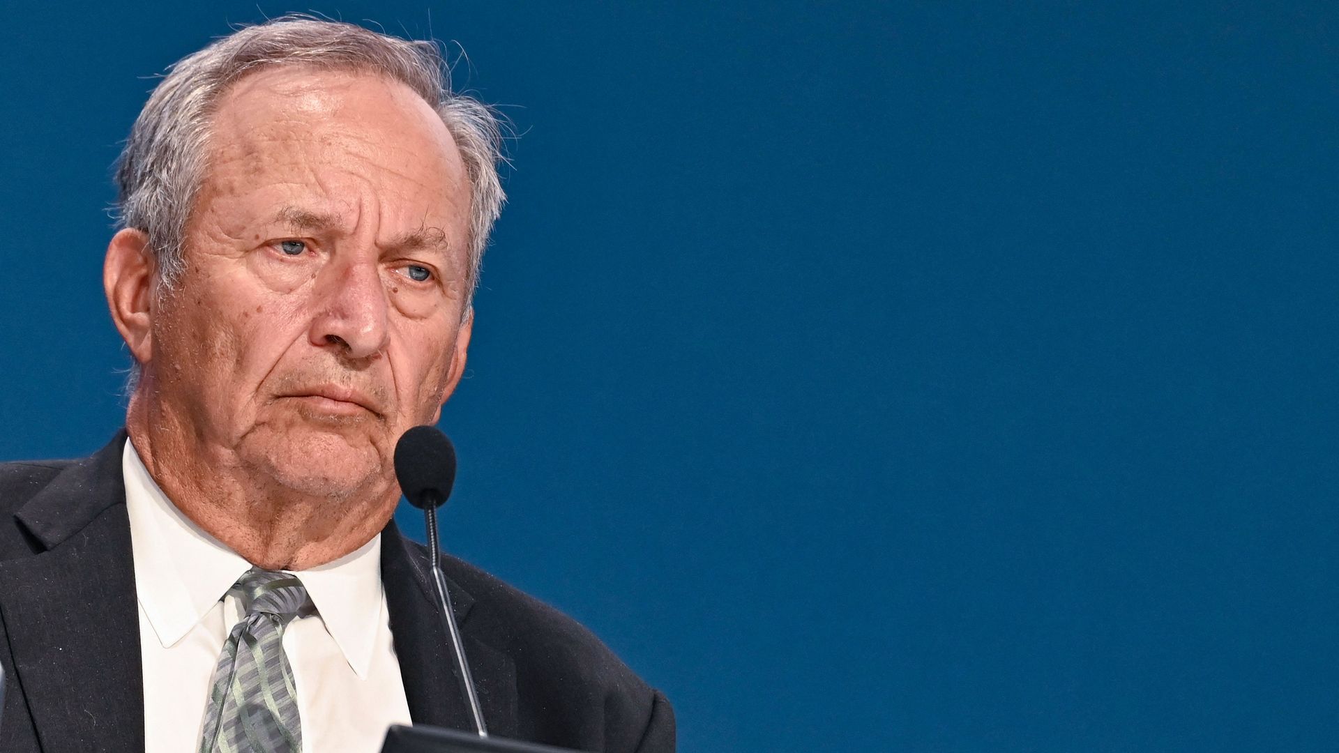 Image of Larry Summers with wrinkled brow at a microphone