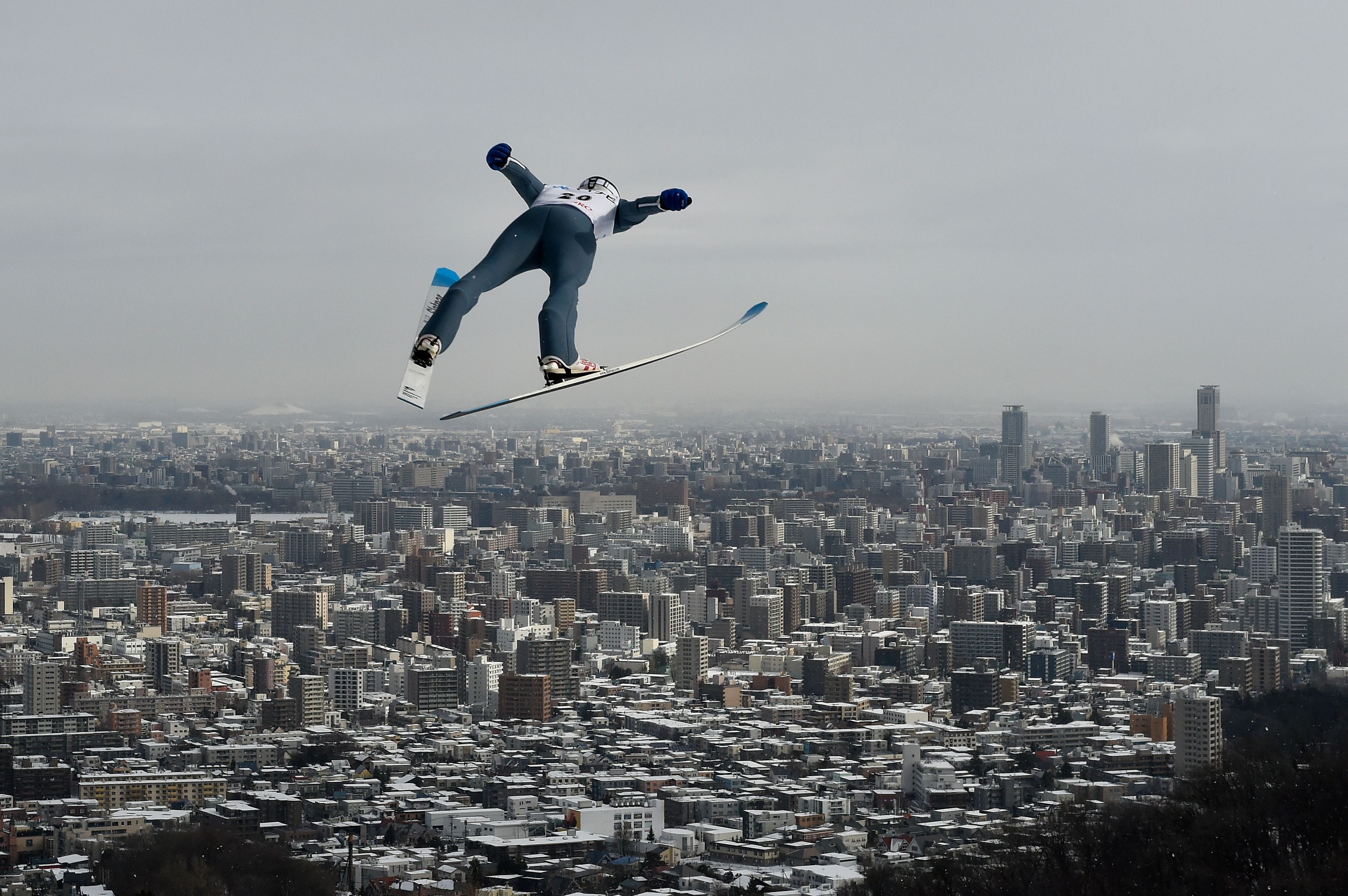 Skier jumping with city in background