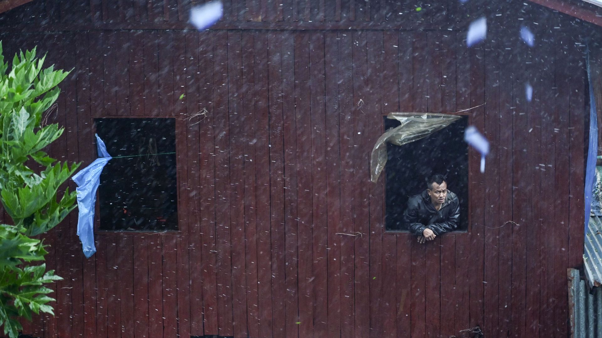 A local resident looks from a window in Myanmar as Tropical Cyclone Mocha hits.