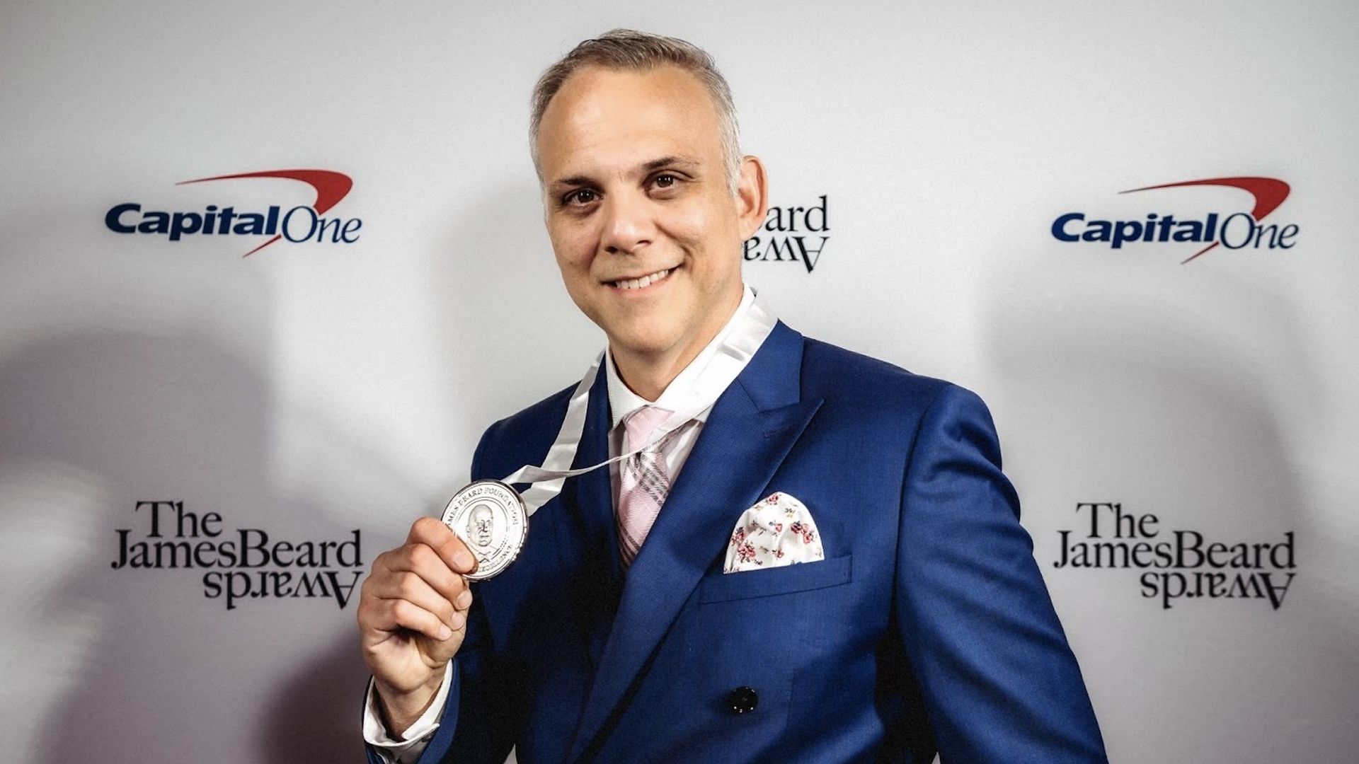 Miami journalist Carlos Frias posing with his James Beard Award