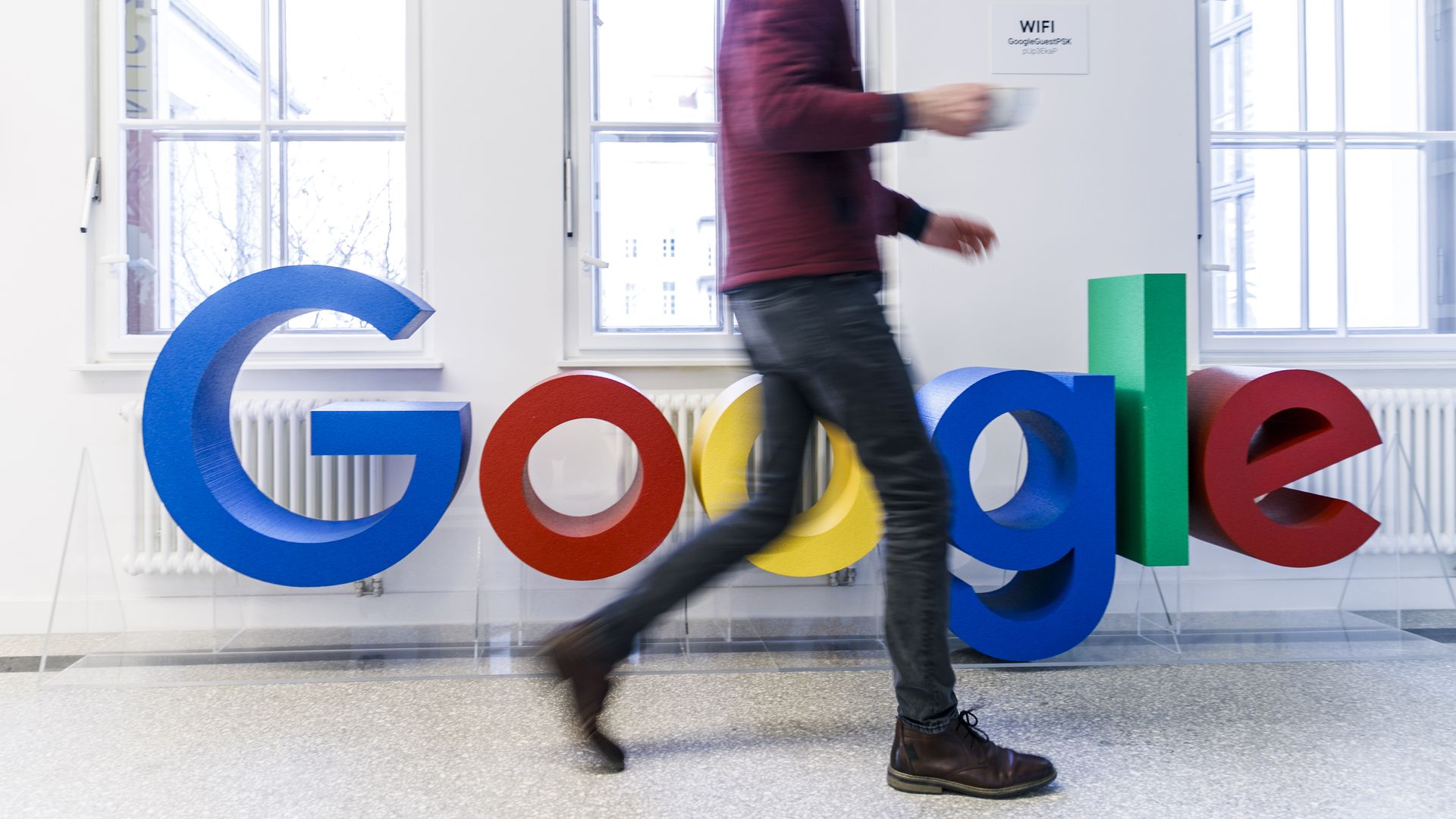 Google logo with man walking in front of it
