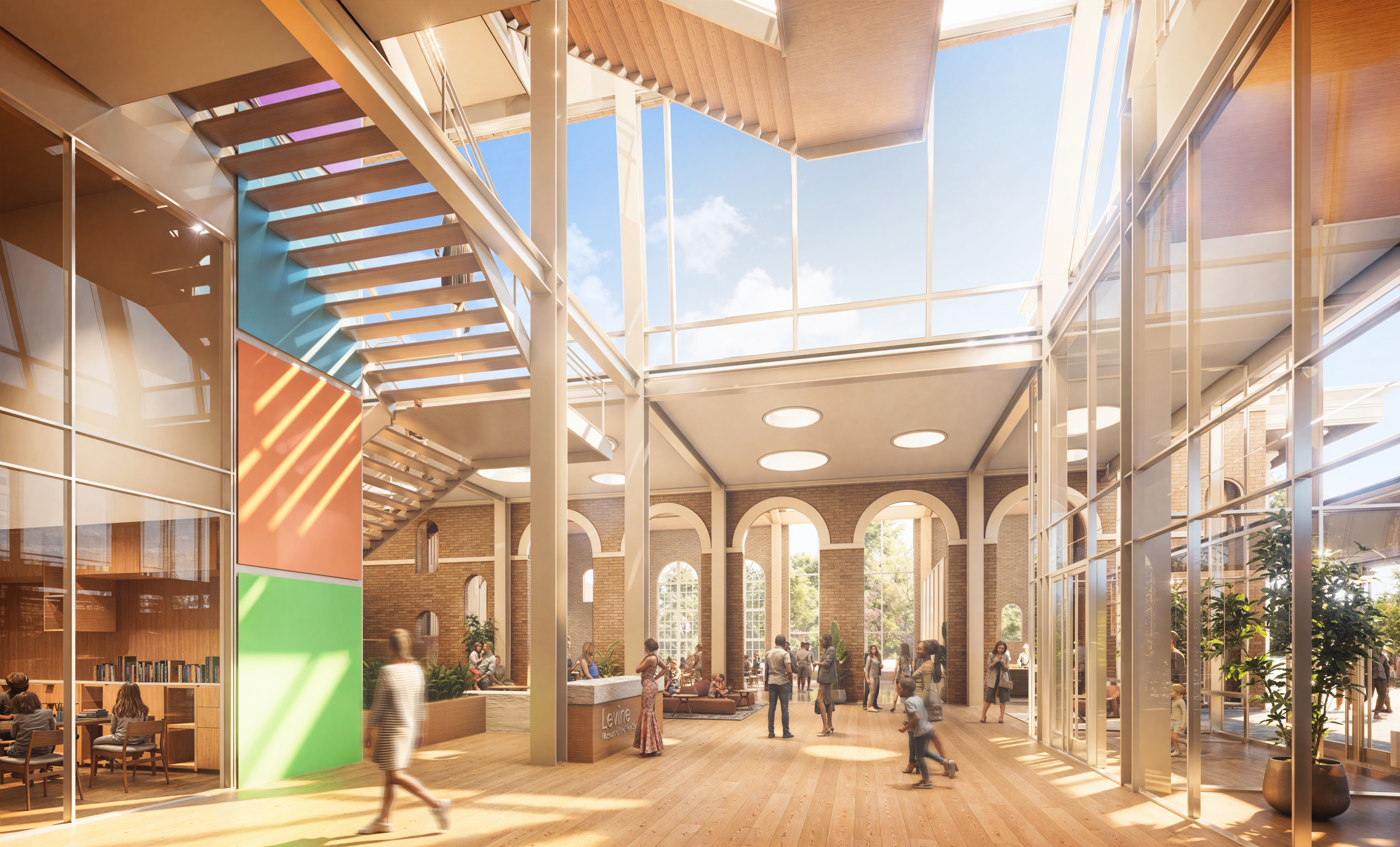 Bright, spacious modern lobby with high ceiling, large windows, wooden floors, colorful wall panels, people walking and chatting, and a staircase leading to an upper floor with blue sky visible.