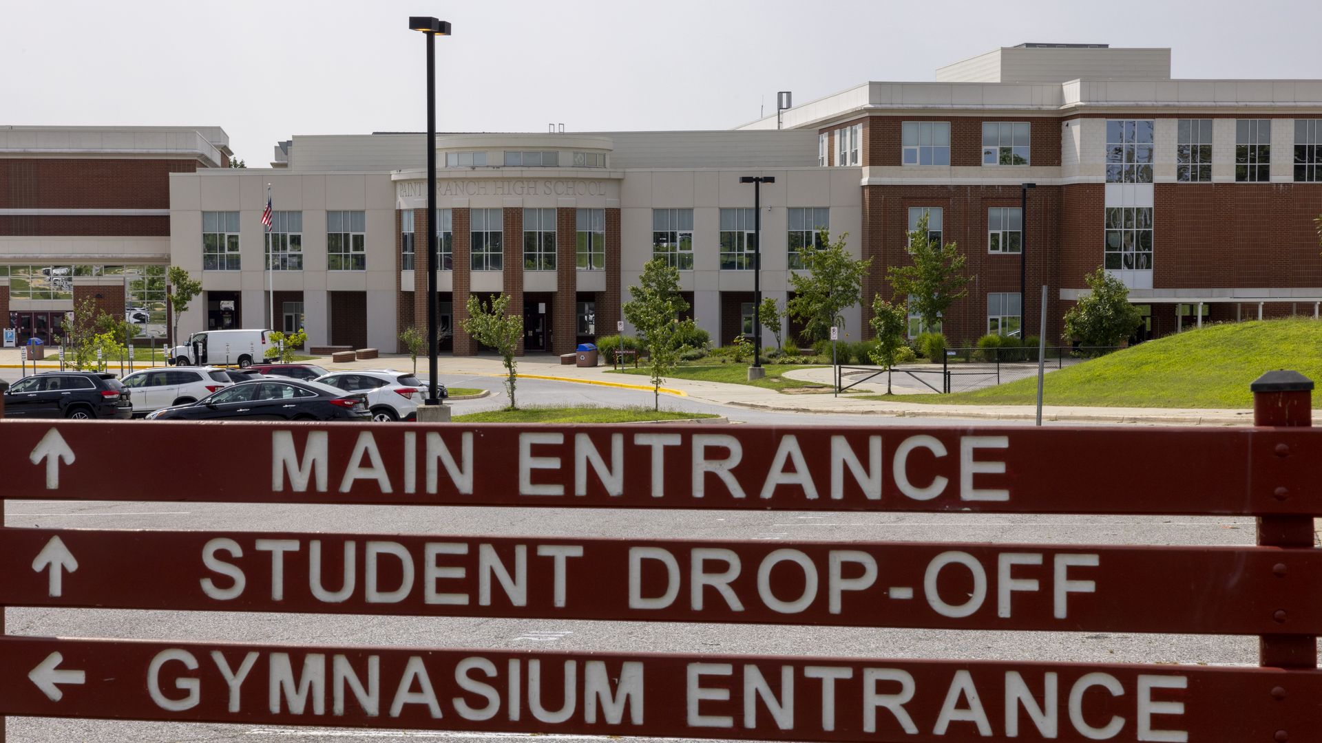 The exterior of Paint Branch High School in Burtsonville, with a sign directing drivers to the main entrance, gym entrance and student drop-off in the foreground.