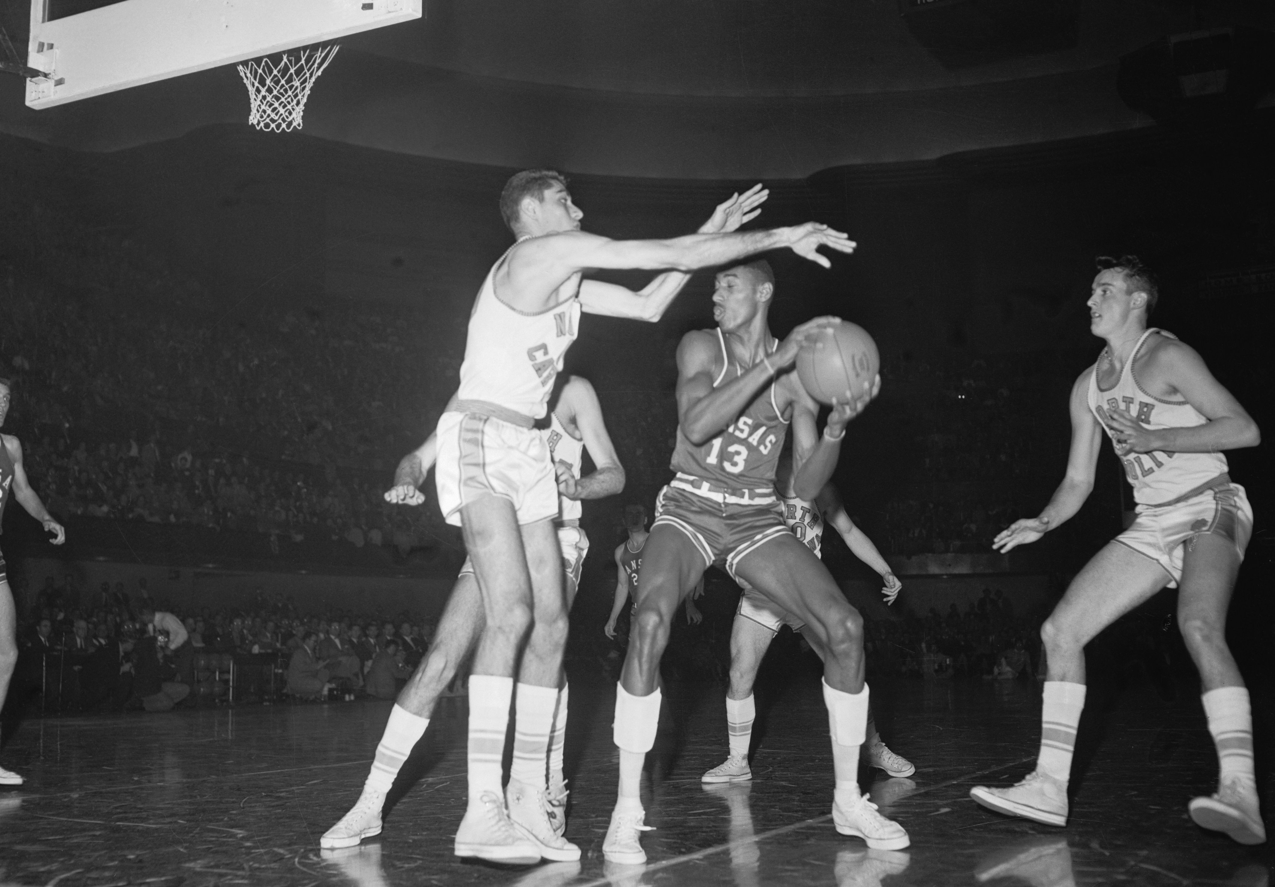 (Original Caption) Titans Battle. Kansas City, Kans.: All American Lennie Rosenbluth (left), of North Carolina, sets up a block on All-American Wilt Chamberlain, of Kansas, during the NCAA National Championship game at Kansas. Undefeated North Carolina won in the third overtime period, 54-51.