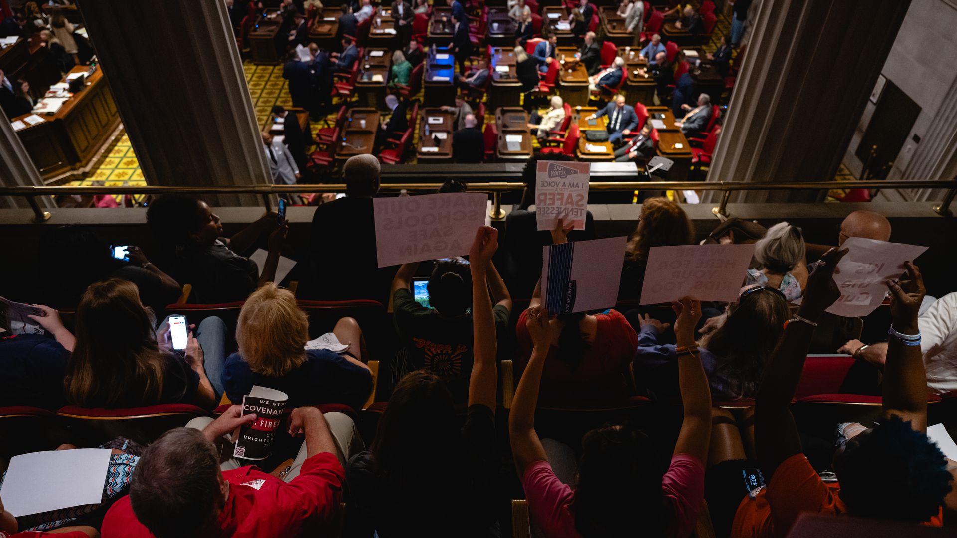Spectators in the gallery of the House chamber wave signs during a special session at the Tennessee State Capitol.