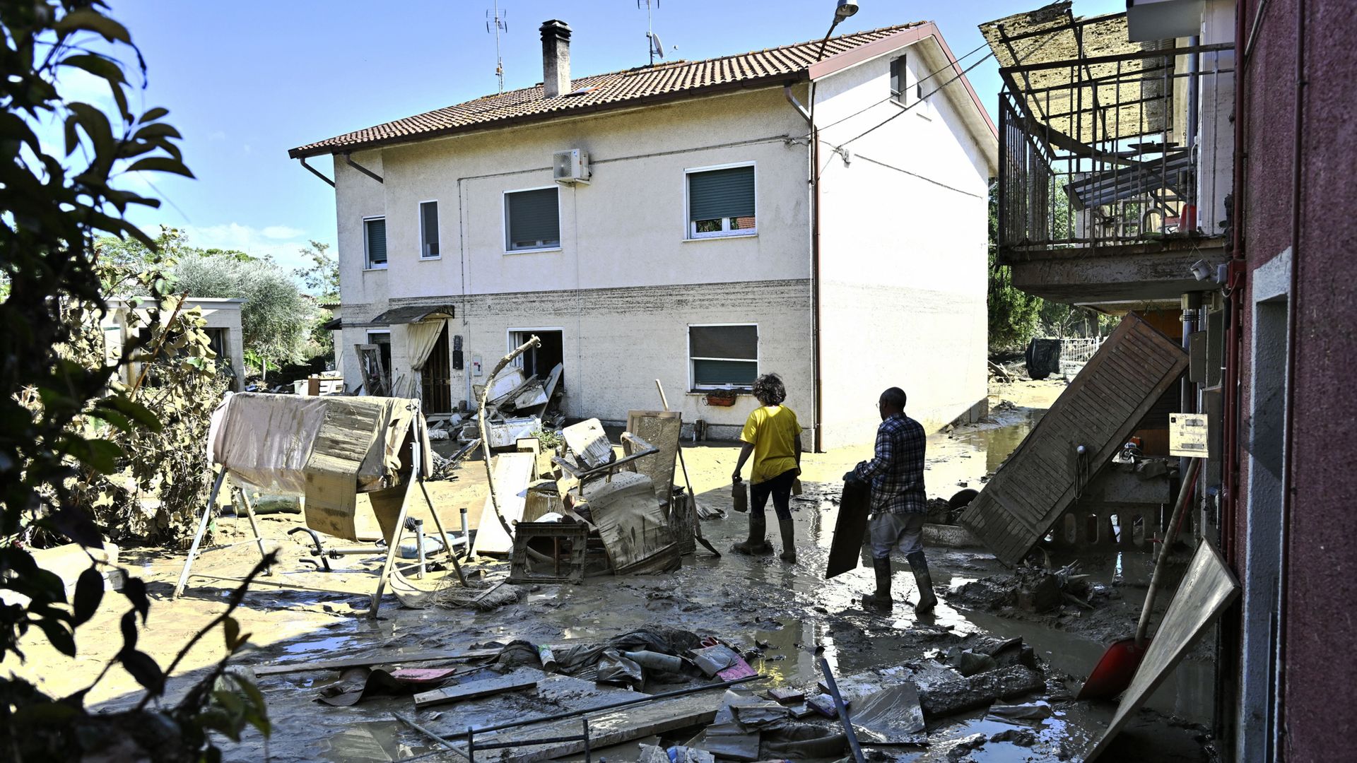 People cleaning outside a flooded house in Pianello di Ostra, Italy, on Sept. 16.