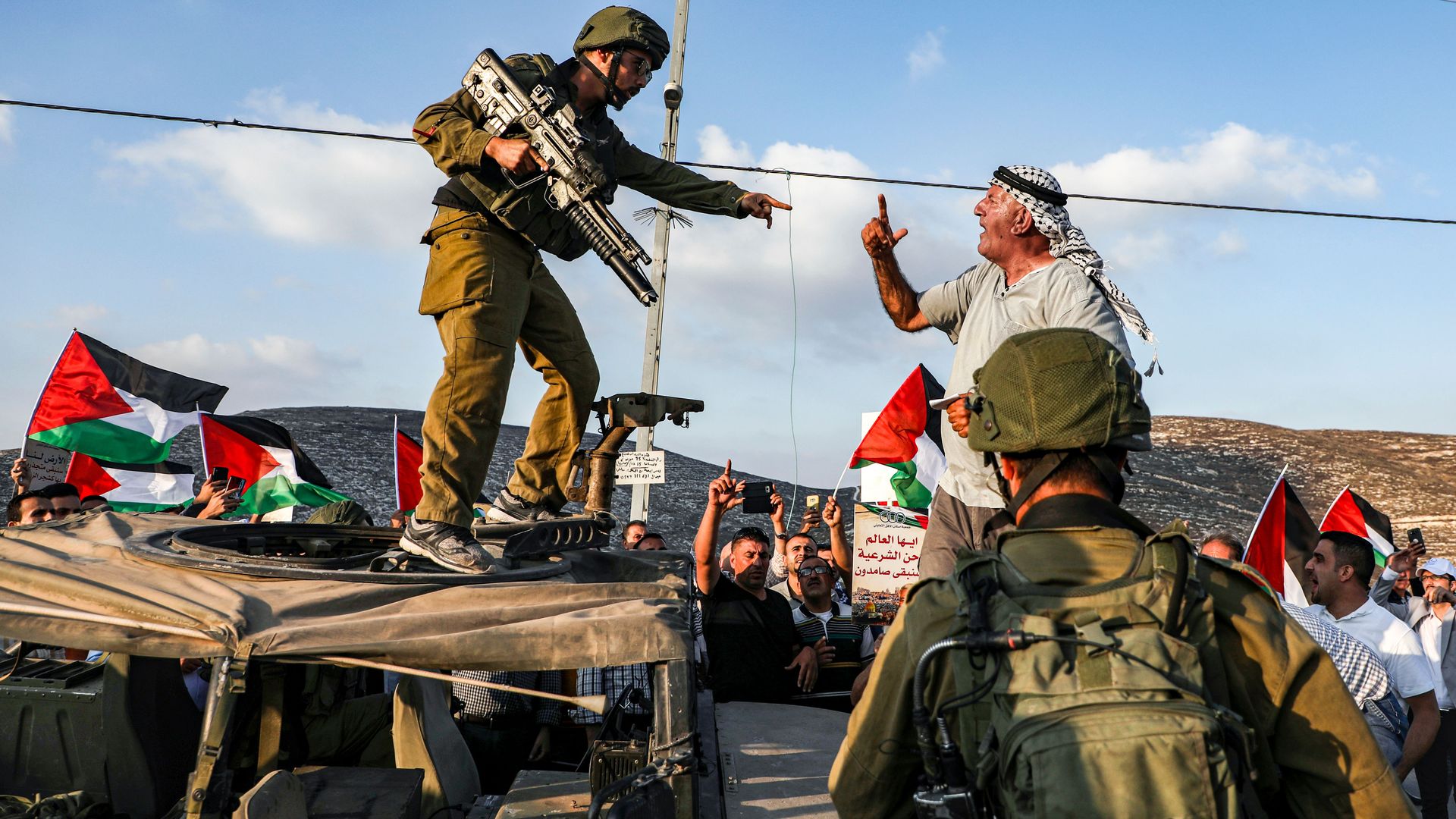 A Palestinian protester yells at an Israeli soldier as he confronts him atop an Israeli army vehicle during a protest on September 4, 2019.