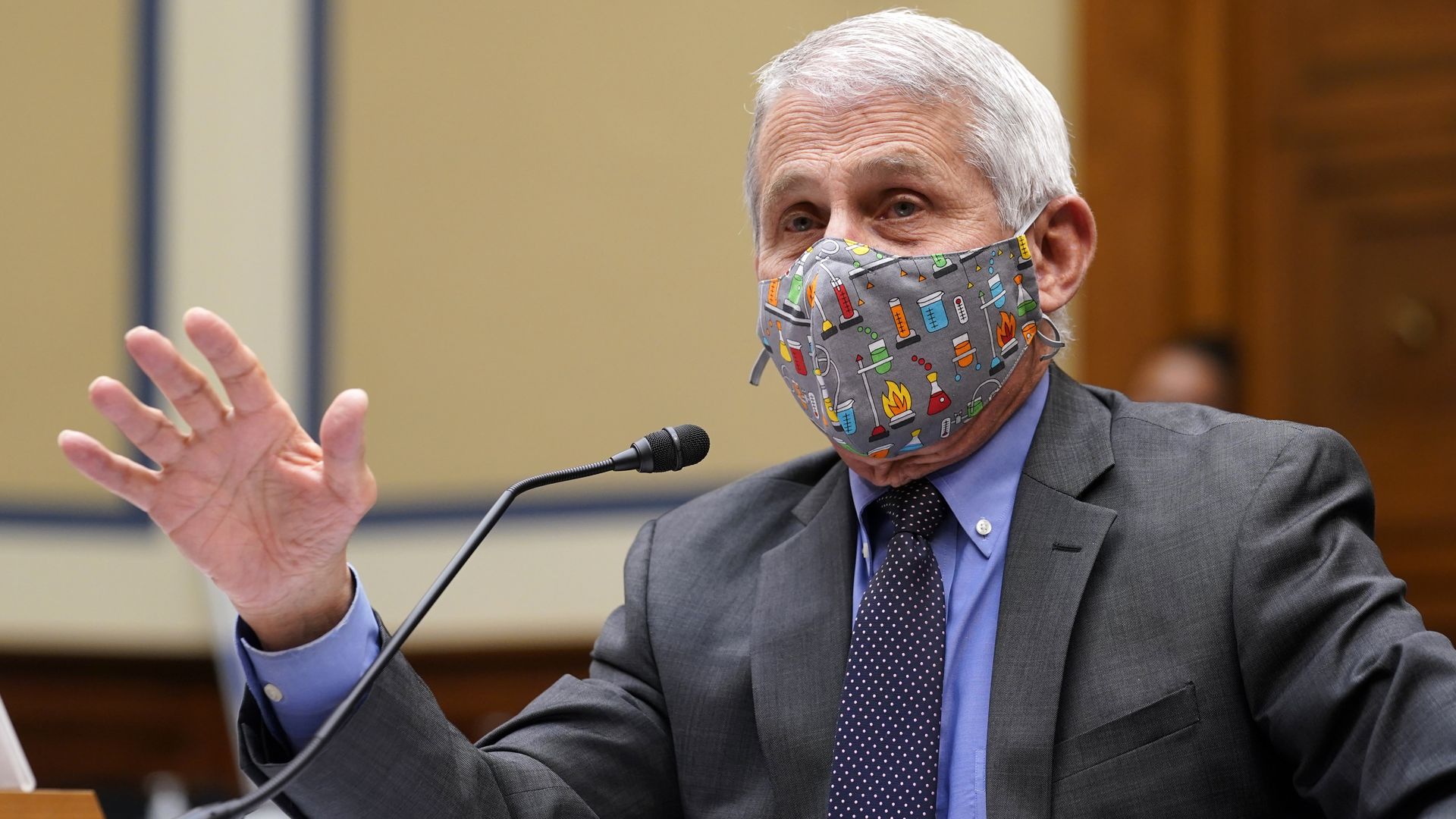 Anthony Fauci wears a mask while speaking into a microphone