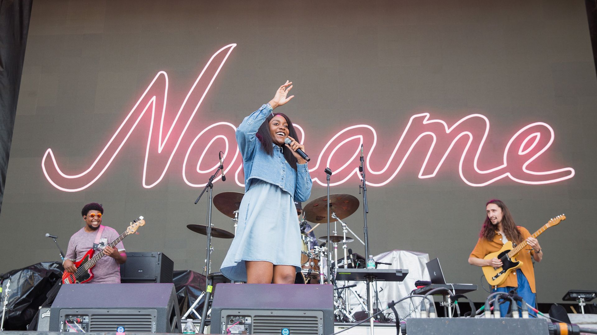 Photo of a band on stage at an outdoor concert. 