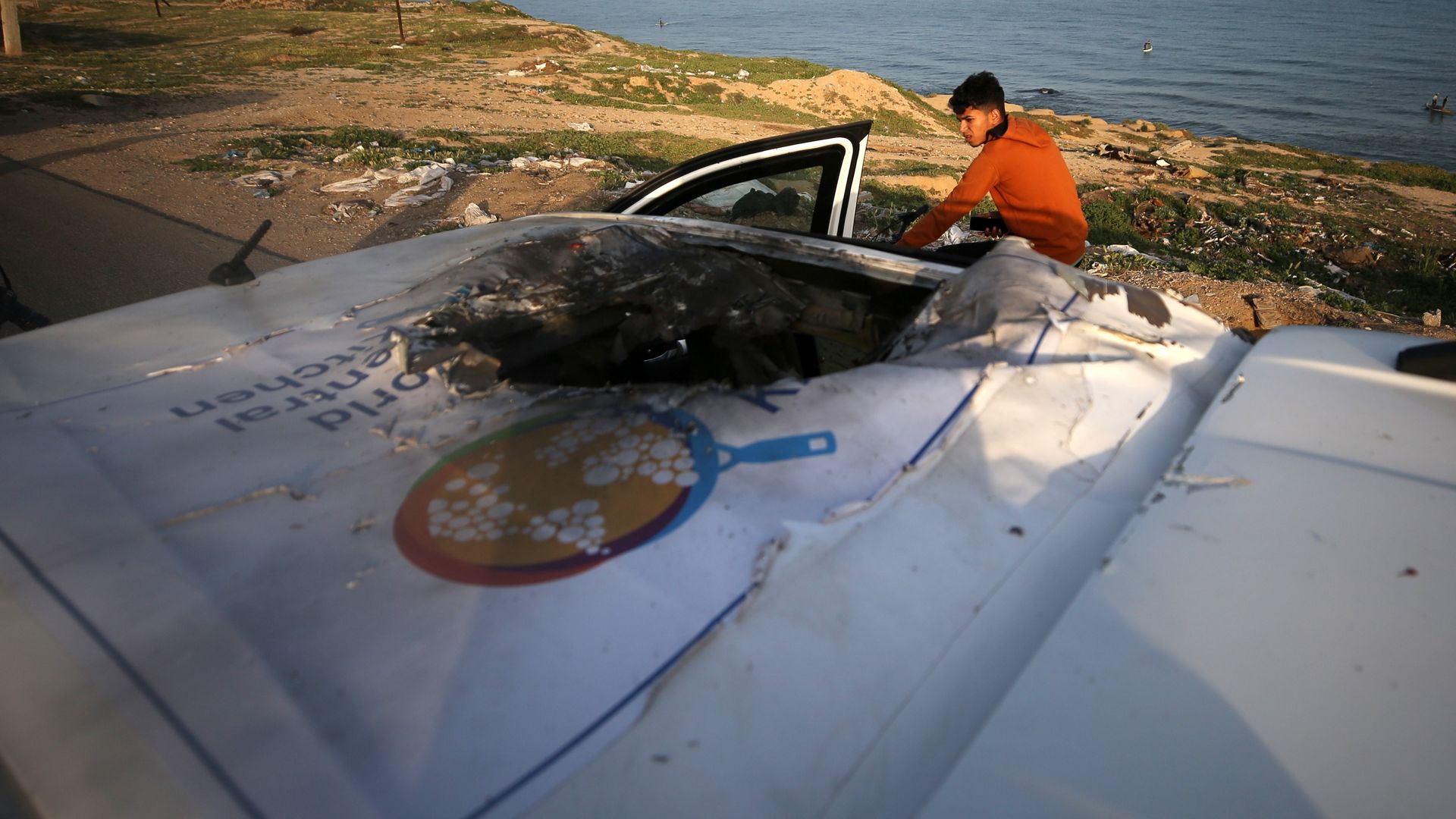 A person inspects a World Central Kitchen vehicle hit by an Israeli airstrike.
