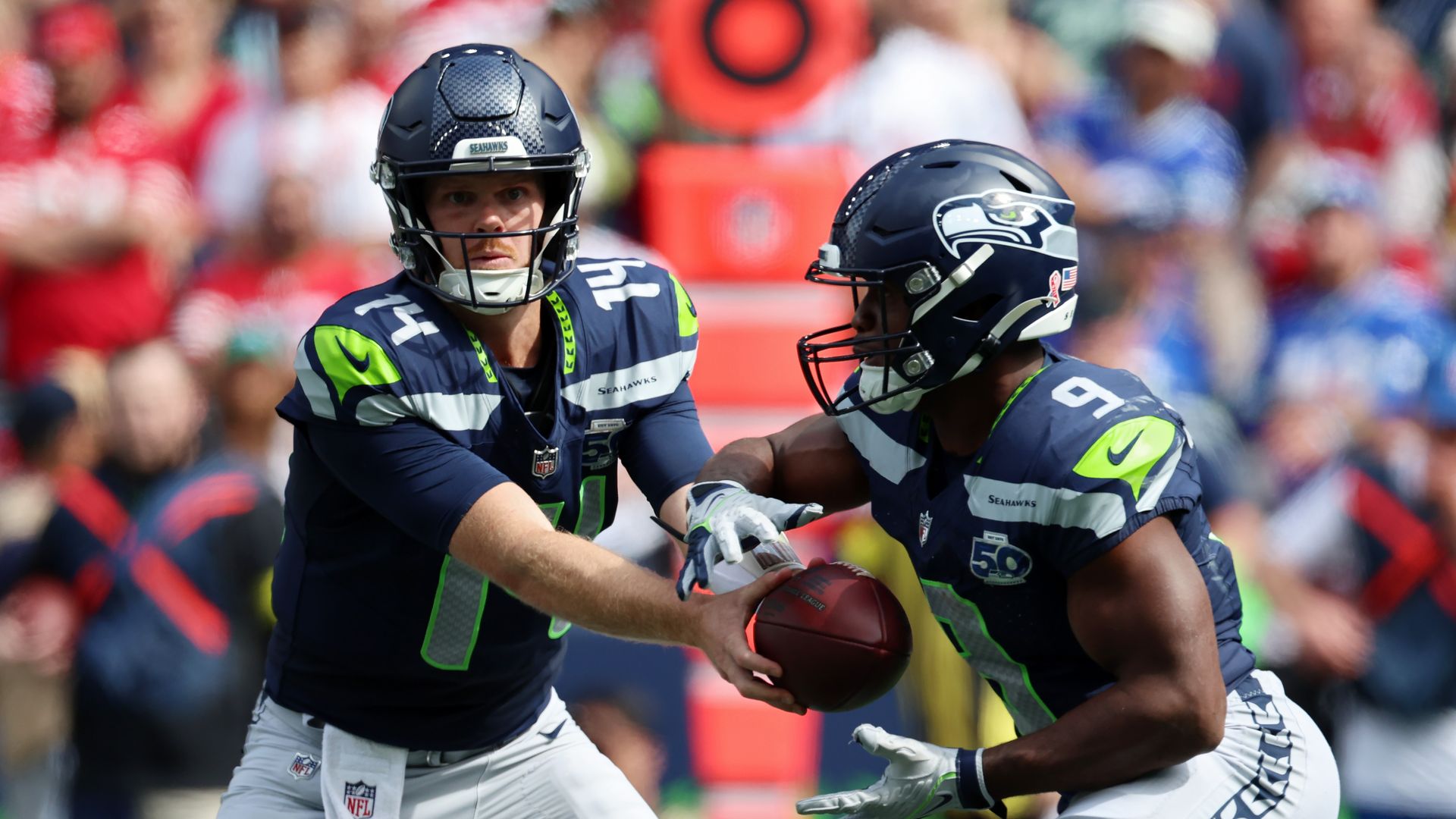 A quarterback hands off the football to another player.  