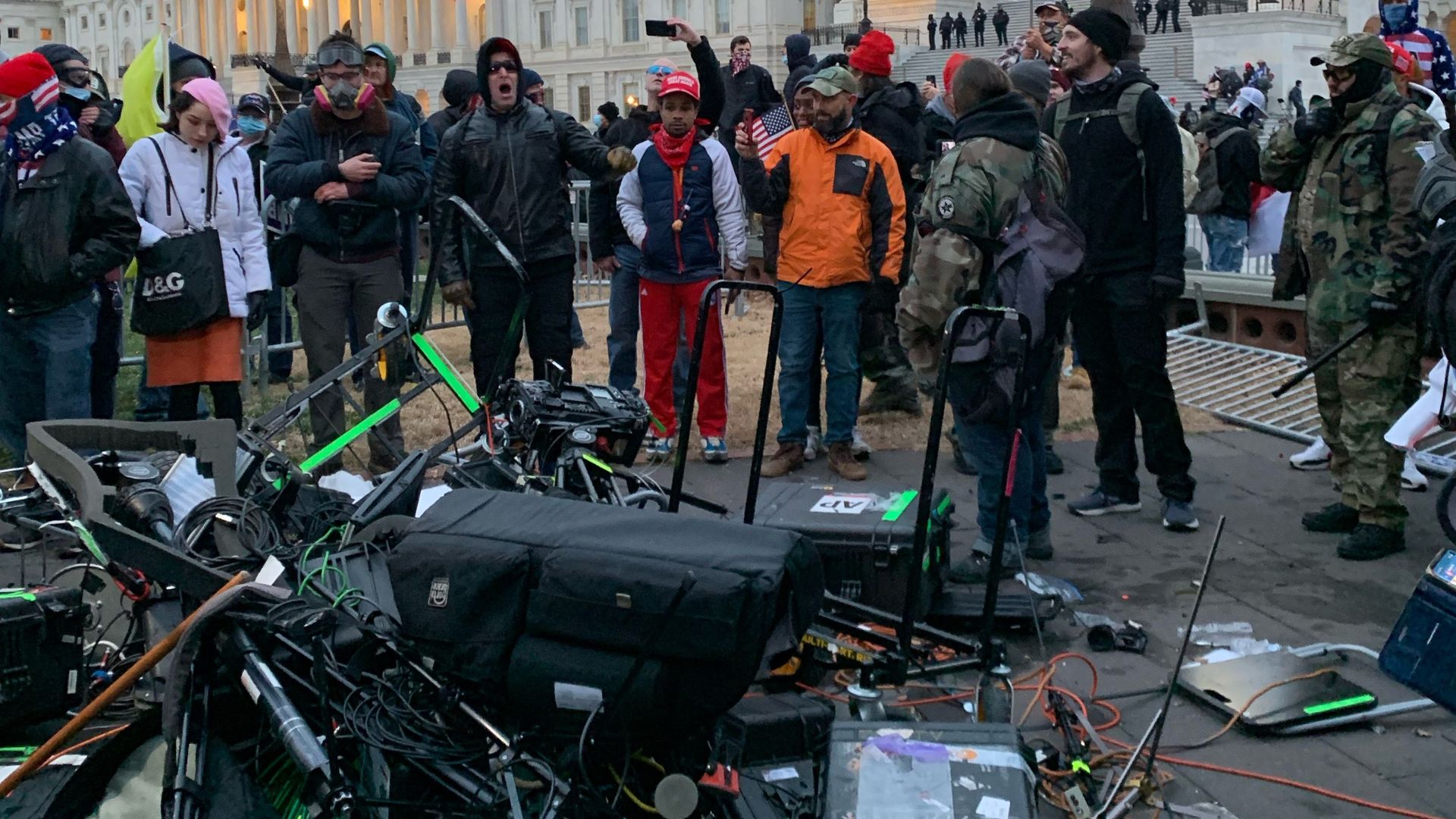People stand around media equipment destroyed by Trump supporters outside the US Capitol in Washington DC on January 6, 2021