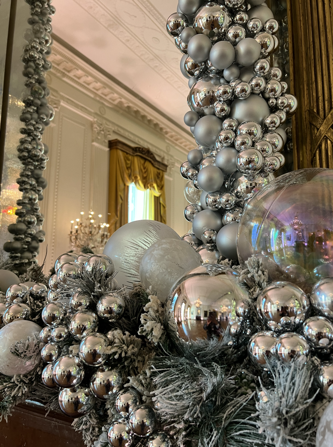 Large silver ornaments over a mantle in the East Room.