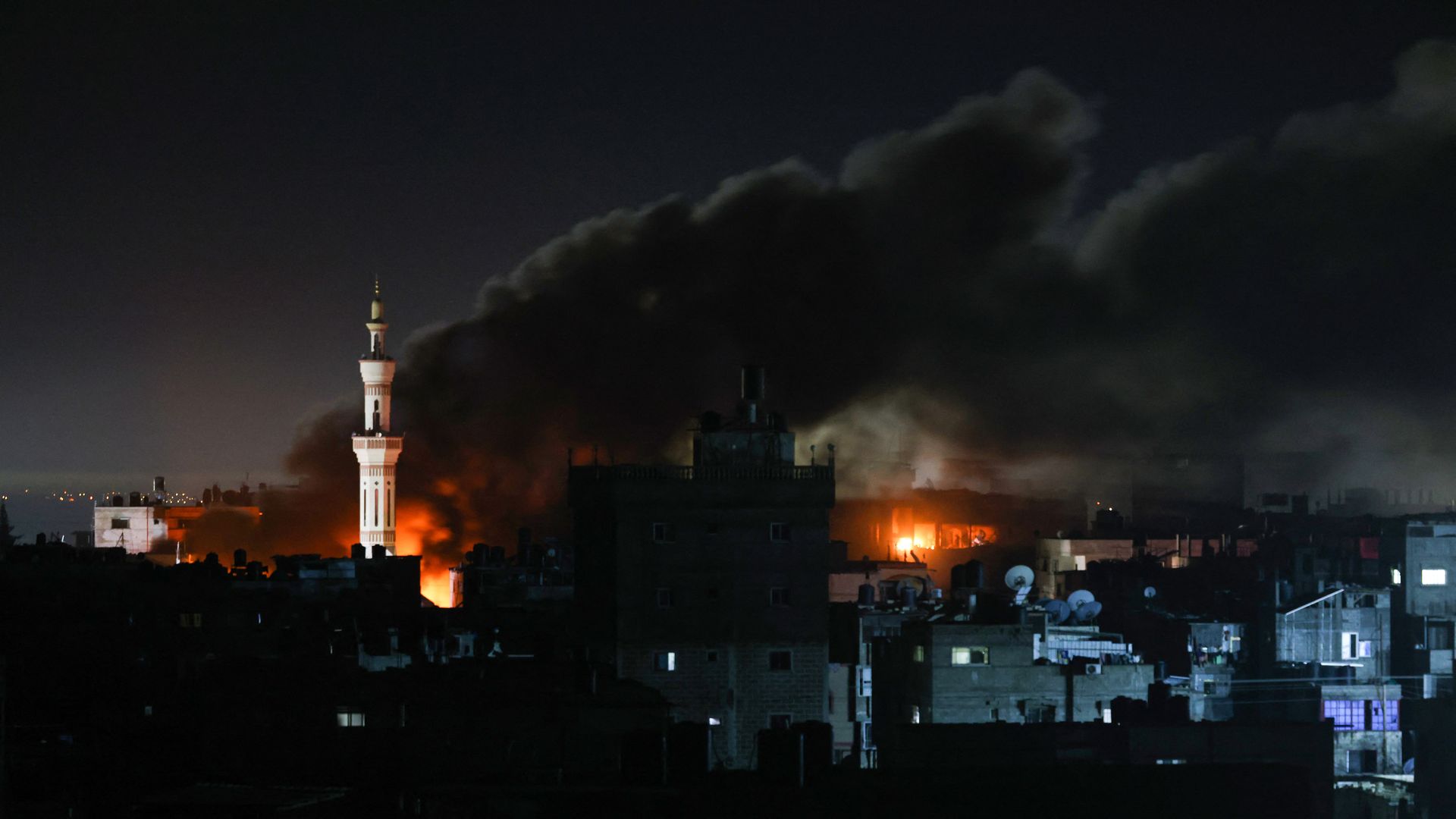 Dark smoke billowing from fires in the Gazan city of Rafah at night time. 