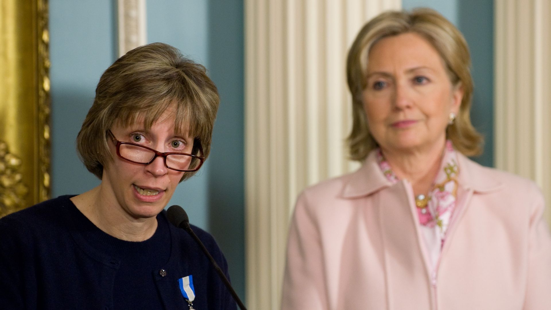 Hillary Clinton stands alongside Lynne Tracy (L) after presenting her with the Secretary's Award for Heroism during a ceremony at the State Department
