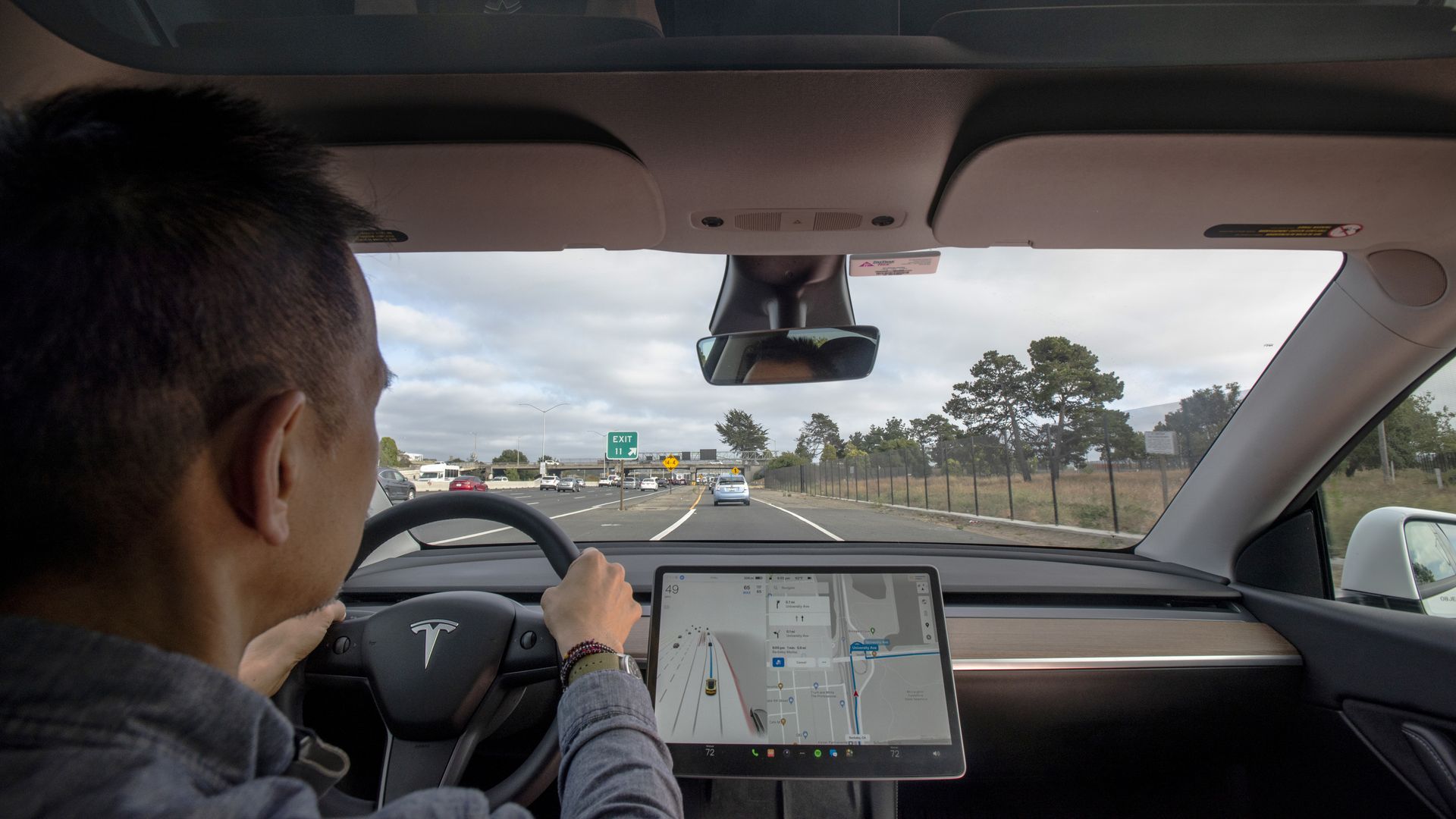 A person behind the wheel of a Tesla Model Y with the company's FSD system engaged