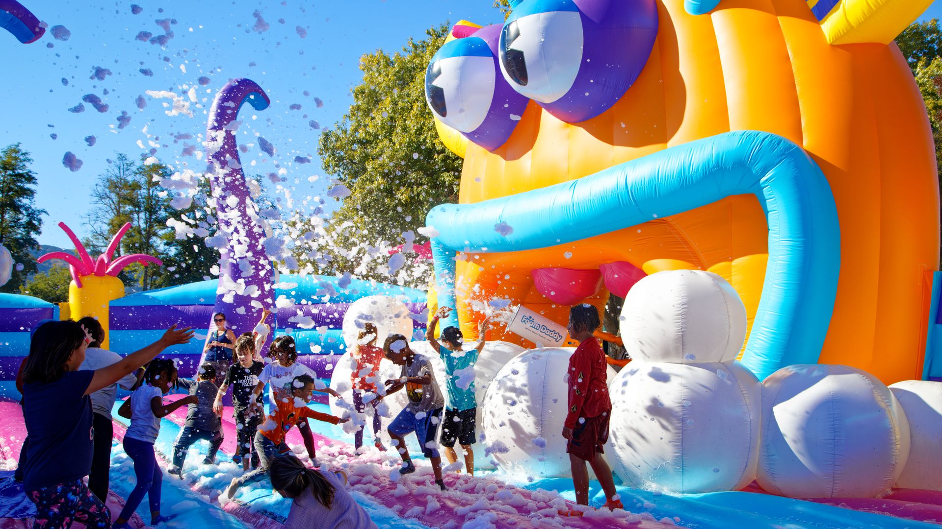 Kids playing with bubbles on an inflatable octopus.