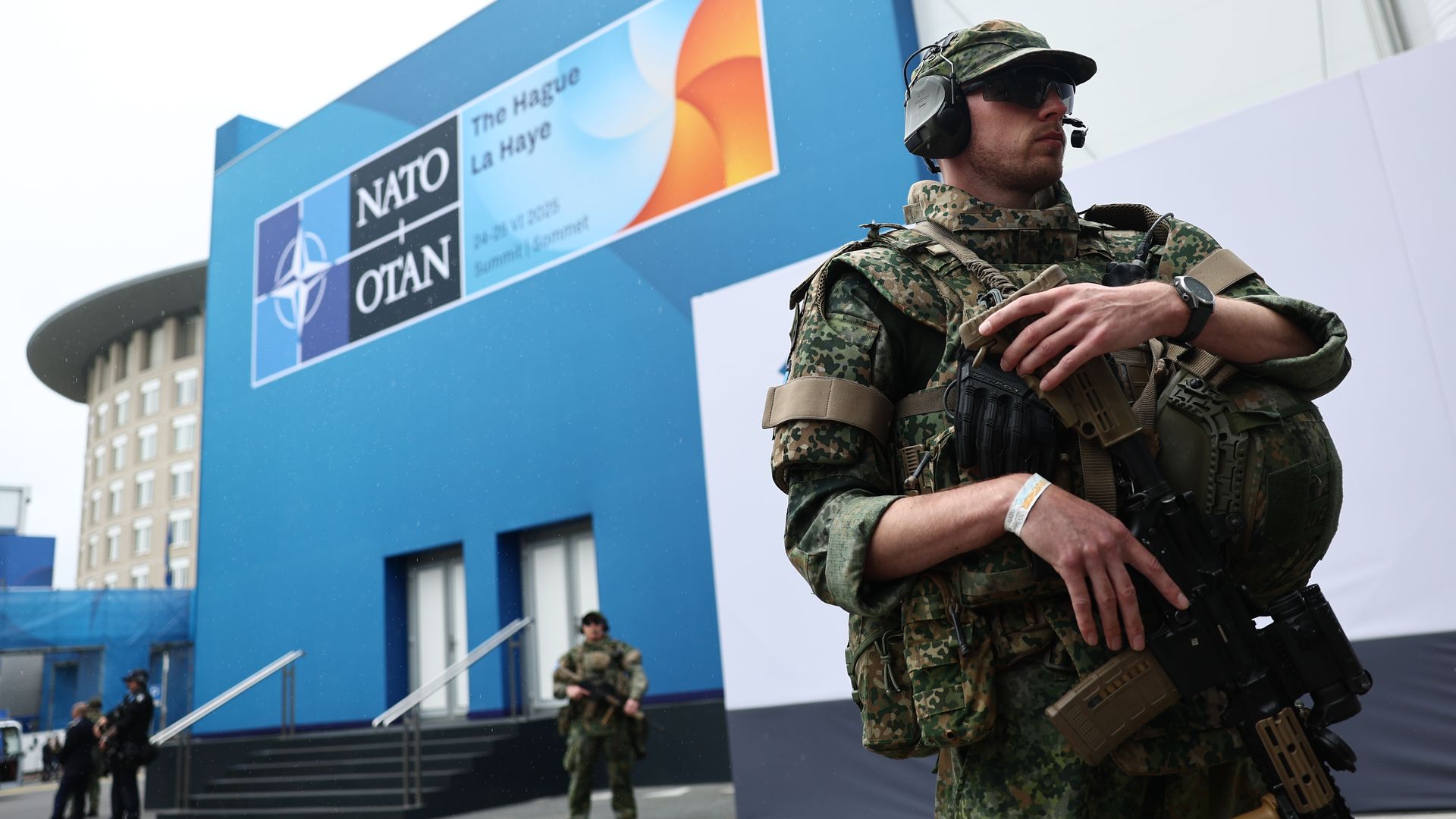 Armed military guards stand outside the NATO meeting in the Netherlands.