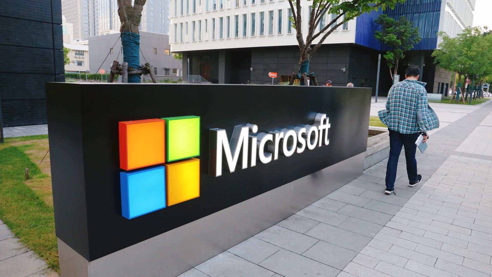 A man walks past a Microsoft sign outside an office building in Shanghai, China.