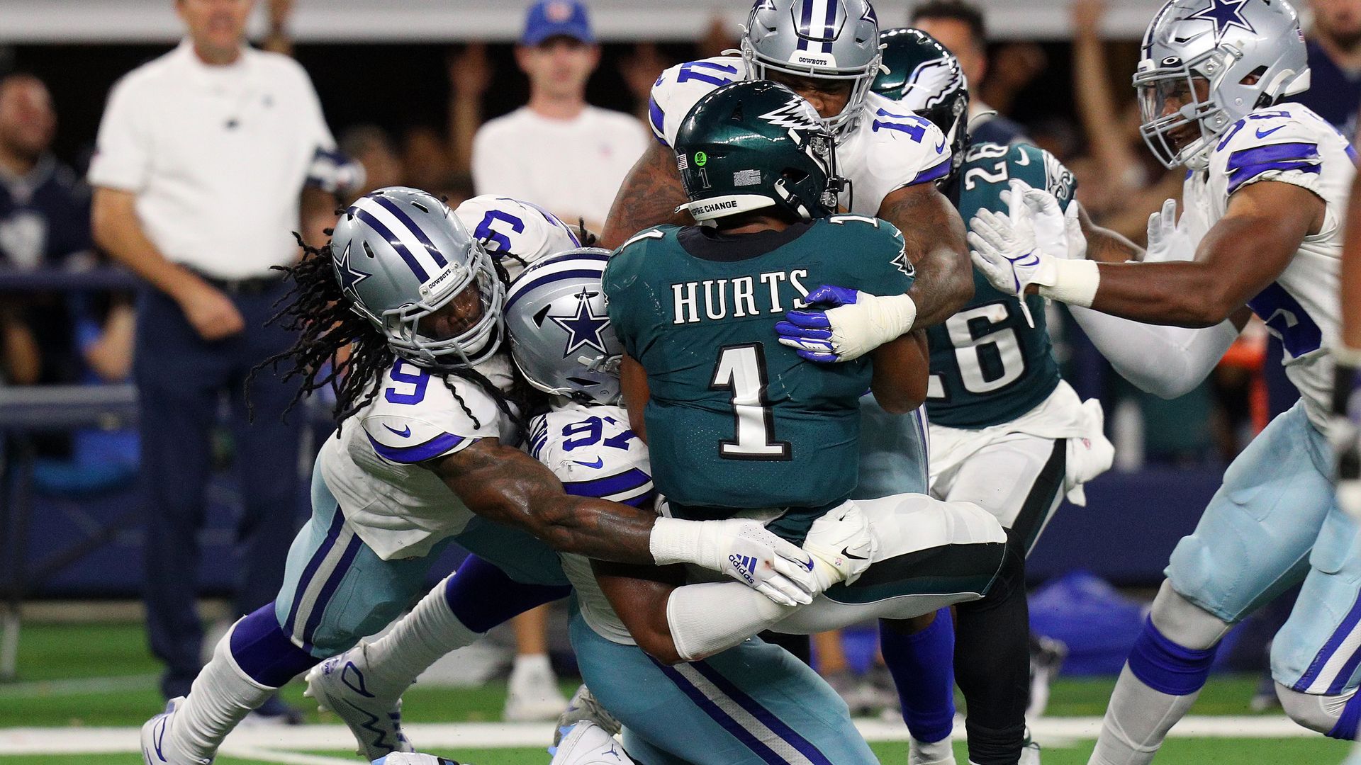 Eagles QB Jalen Hurts taken down by a group of Dallas Cowboys tacklers.