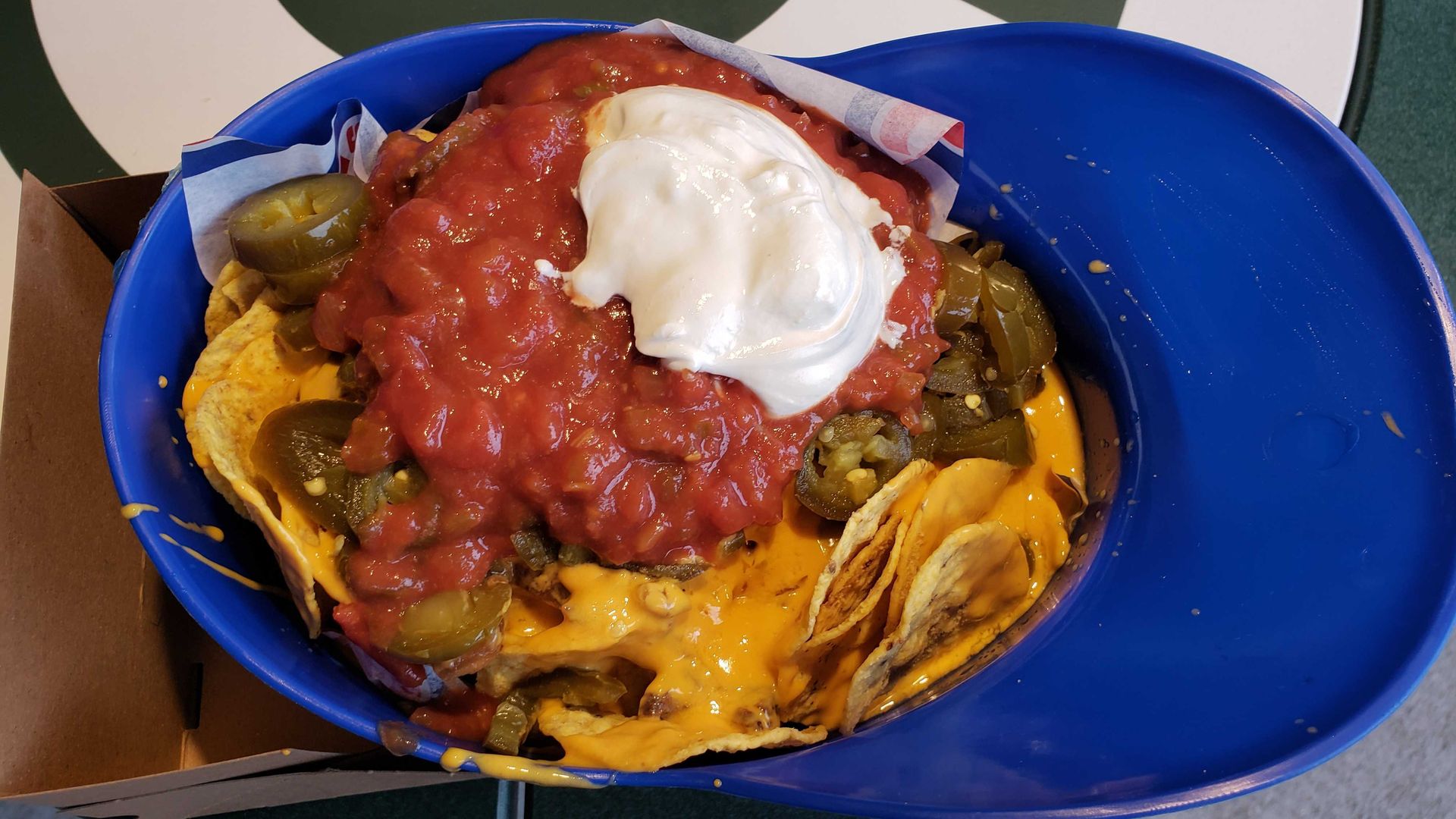 Photo of nachos in a baseball helmet.