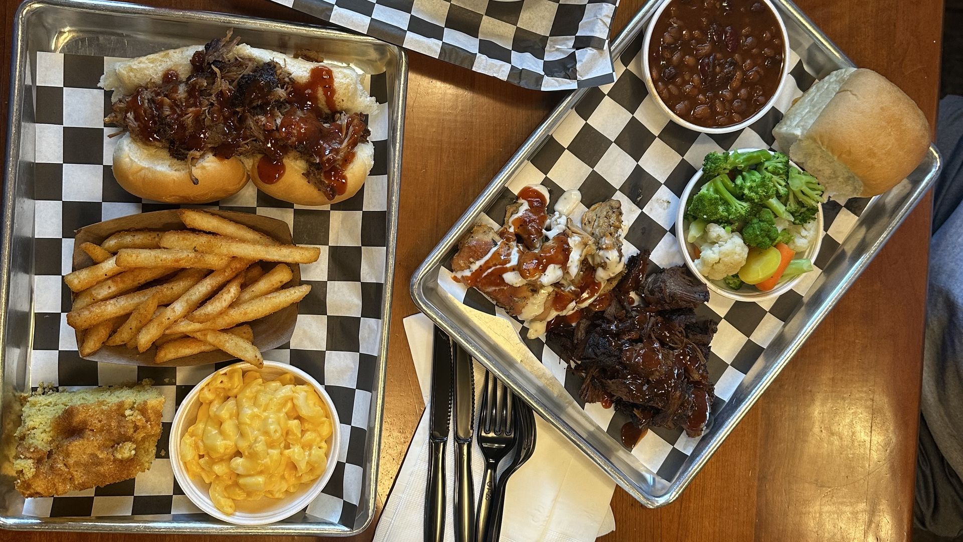 A table featuring BBQ food like fries, pork, baked beans and mac n cheese.