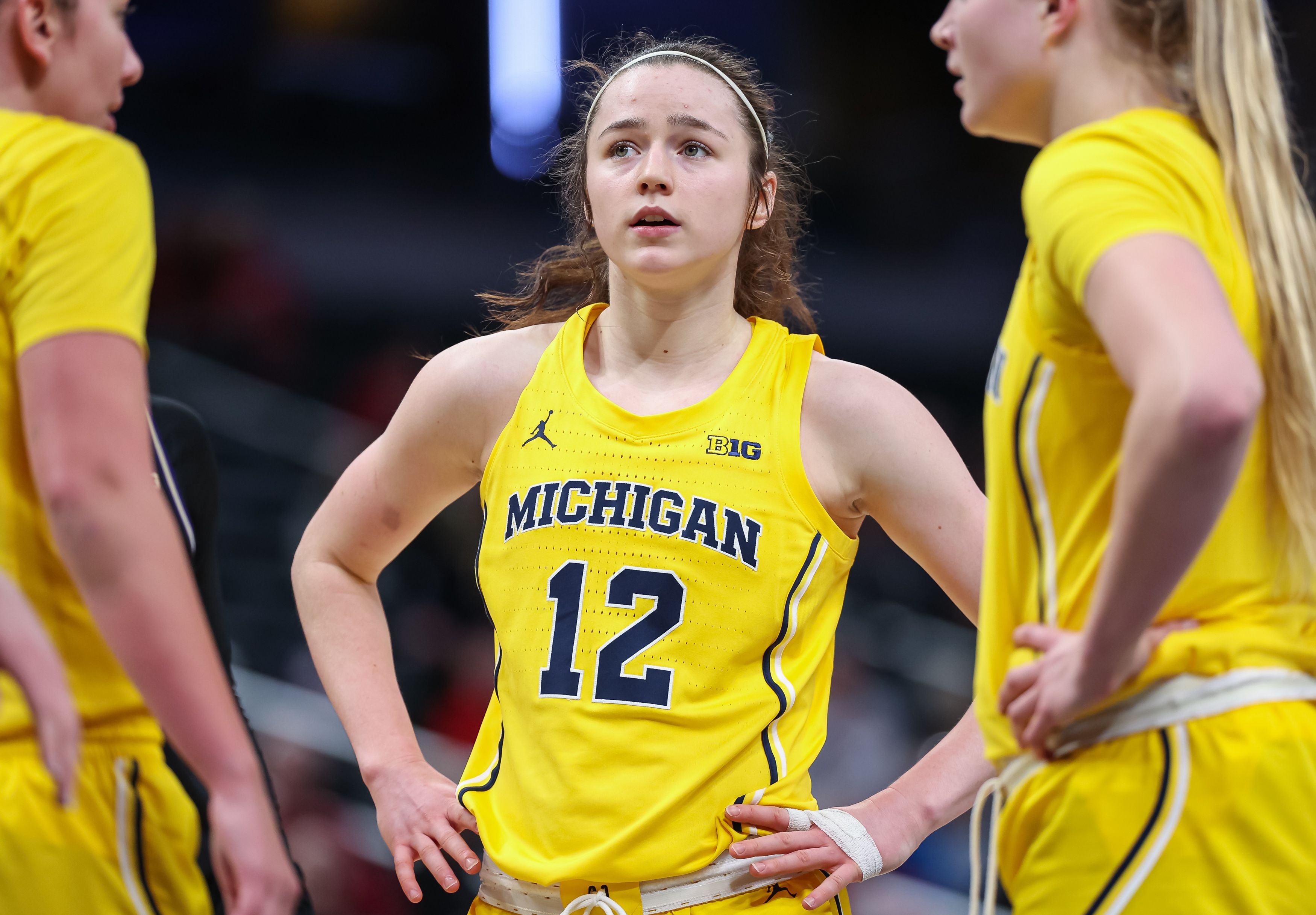 Photo of women basketball players huddling during a game.