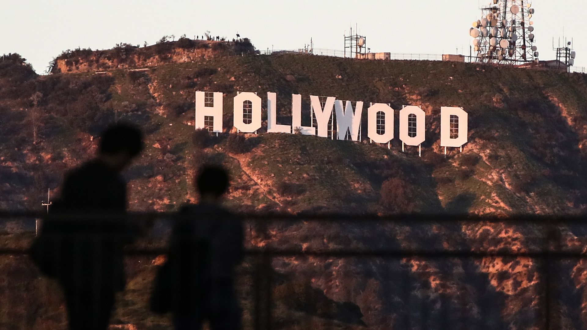 Two silhouettes in front of the Hollywood sign